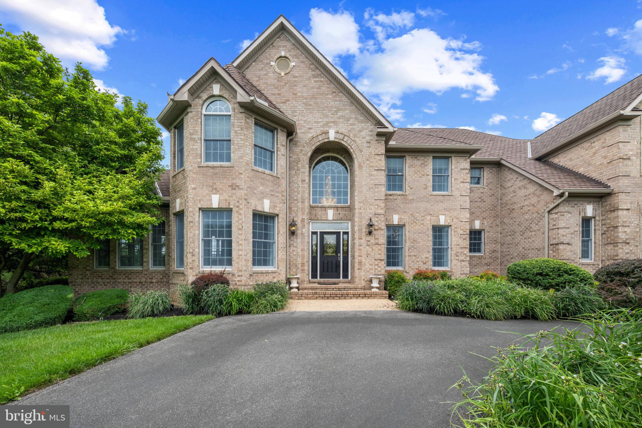 Spanning 5,669 finished square feet, this extraordinary estate showcases refined design, luxury finishes, and exceptional craftsmanship throughout. // LVT flooring flows across the traditional main level, beginning in a grand two-story foyer with marble floors and a striking chandelier that sets an impressive tone. To the left, the formal living room with graceful curved architecture opens through triple arched walkways into a sunroom with exterior access, while the formal dining room to the right impresses with elegant lower wainscoting. Stately columns define the dramatic family room, where soaring two-story ceilings, oversized arched windows, built-in bench seating, and a brick-accented two-sided gas fireplace create a breathtaking central gathering space. Additional main-level highlights include a well-appointed private study, a built-in work station, a convenient laundry room, and a stylish powder room with marble floors. // The beautifully remodeled 2024 kitchen is both stunning and functional, featuring Wolf® and SubZero® stainless steel appliances including double ovens, a marble-inspired backsplash, abundant white cabinetry with glass-front accents and open shelving, an oversized island with bar seating, pantry storage, and a striking circular breakfast room wrapped in panoramic windows beneath soaring ceilings. // The opulent primary suite serves as a luxurious private retreat with hardwood floors, a raised sleeping area with a double tray ceiling, and a sophisticated sitting room framed by stately columns and vaulted ceilings. Dual walk-in closets—including one with built-ins and a dedicated vanity area—offer exceptional storage, while the spa-inspired ensuite, remodeled in 2018, features skylights, a Roman soaking tub, dual-sink vanity, separate glass-enclosed shower, and exquisite tilework throughout. // Three additional upper-level bedrooms each offer walk-in closets, including one with a private attached bath, while the remaining two share a beautifully updated dual-access bathroom. All secondary bathrooms were refreshed in 2021. // The walk-out lower level expands the home’s impressive lifestyle offerings with a spacious recreation room featuring a statement accent wall and eclectic full bar, a versatile bonus area ideal for a billiards lounge, home gym, or flexible entertaining space, plus two additional bedrooms, one with dual access to a full bathroom—perfect for guests or multi-generational living. // Additional updates include the washer and dryer, three HVAC systems, and water heaters for added peace of mind. Additional highlights include a full home Generac generator and a full home Sonos® audio system. // The outdoor setting is truly exceptional, designed as a private resort retreat with an expansive deck featuring a screened gazebo and built-in grill, an extensive patio surrounding the in-ground pool (replastered in 2022), complete with a submerged sun shelf, diving board, and raised built-in spa, plus a covered pavilion showcasing a full outdoor kitchen and fireplace with TV capabilities. A built-in firepit lounge and multiple spaces for al fresco dining and relaxing complete the extraordinary backyard experience.