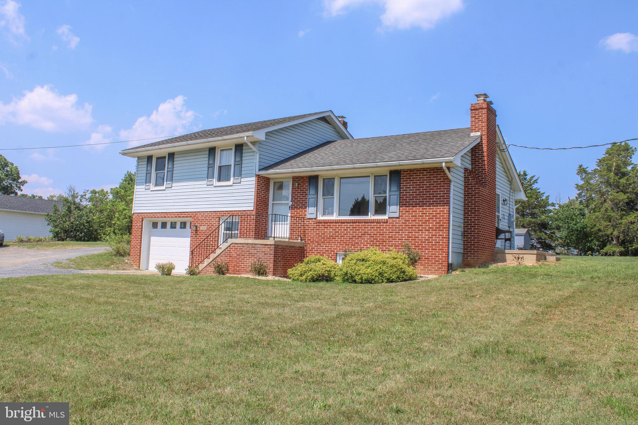 Conveniently located near I-81 and Route 11, this spacious split-level home offers comfort, character, and plenty of room to grow.  Beautiful hardwood flooring extends throughout most of the home, while the inviting living room features a classic white brick fireplace with gas logs.  The dining area and kitchen showcase solid pine cabinetry complemented by updated countertops, creating a warm and functional gathering space.  A side patio offers a space to sit and enjoy the outdoors.  The upper level includes three bedrooms, all with hardwood floors and a beautifully updated & tiled bath w/shower. On the middle level, you'll find a full bath with laundry area, including a washer and dryer that convey, along with a separate office space ideal for working from home. The lower basement level offers over 500 square feet of additional space, complete with a wood stove and ready for your finishing touches. A one-car garage provides extra room for a freezer, workbench, or storage. Situated on a large, deep lot, the property offers ample parking and includes both a wood shed and a storage shed, providing plenty of space for tools, equipment, and outdoor essentials.  Broker related.