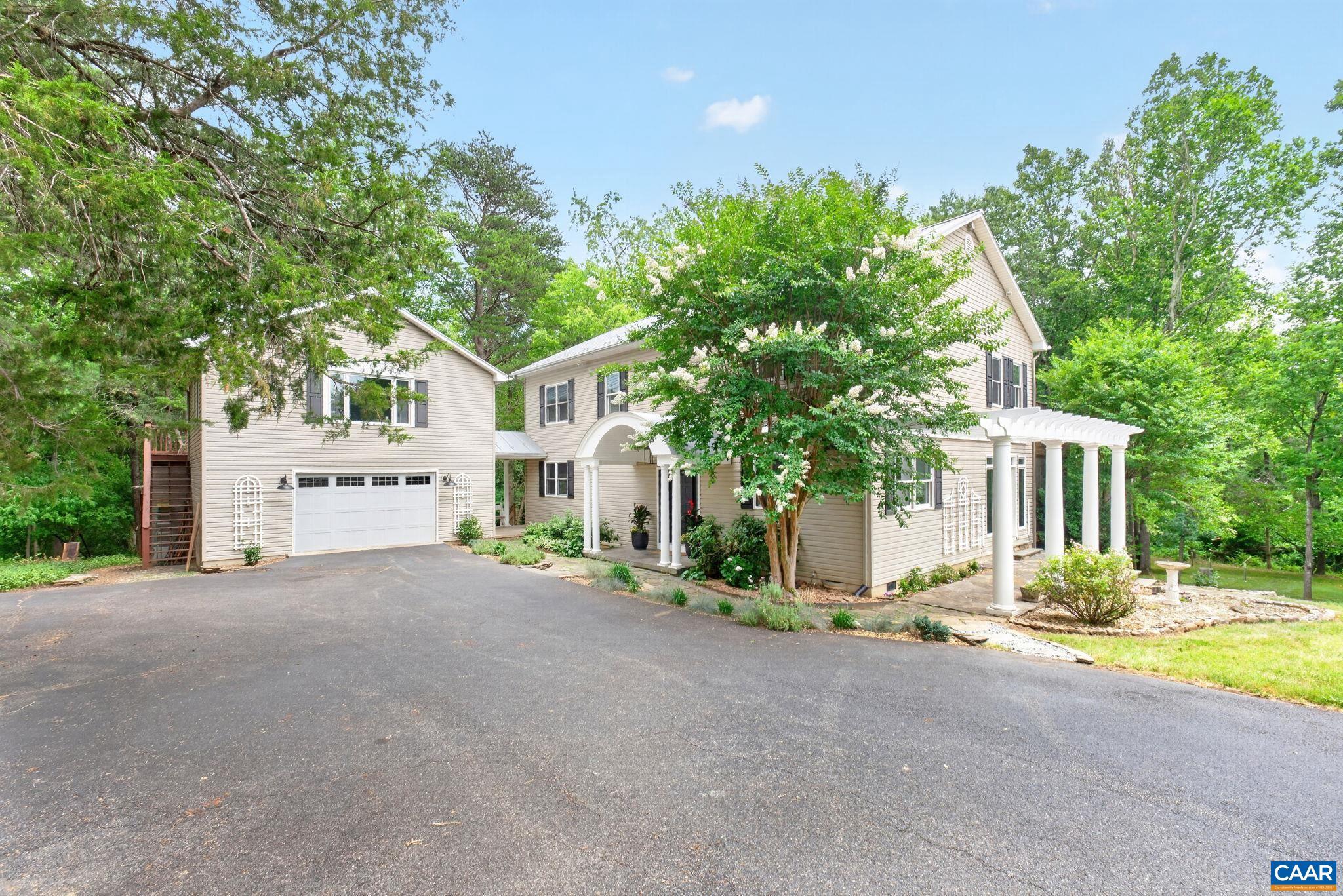 Set on 8 private acres along Lickinghole Creek with walking trail access to Old Trail, this no HOA, Western Albemarle home offers wooded privacy, flexible living space, a detached 2-car garage with 1 bedroom apartment above, and quick access to downtown Crozet. The 4 bed/3 bath main home features 2,784 sqft with refinished hardwood floors on the main level, high ceilings, abundant natural light, and inviting outdoor spaces incl a large side deck, screen porch, garden area, and private upper-level deck. The main level includes an open living room with stone fireplace and wall of windows, dining area with French doors to screen porch, and sunny kitchen with granite counters, stainless appliances, refinished cabinetry, and built-in desk. A main-level bedroom, full bath, and large laundry/mud room add convenience. Upstairs, the primary suite includes a walk-in closet, updated bath with quartz vanity tops, and private deck. A spacious family room/study with built-ins and gas fireplace, additional bedroom, full bath, and office/guest space complete the upper level. Located in Brownsville Elem and Western Ablemarle HS - near Mint Springs Park, Chiles Peach Orchard, Crozet Park, wineries, breweries, UVA, & Blue Ridge Mtns.,Granite Counter