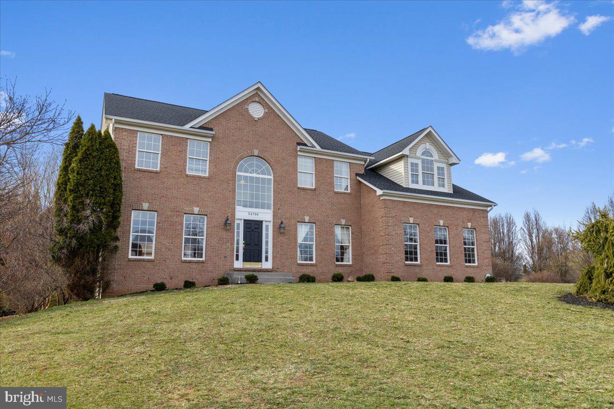 Welcome to this level and picturesque 4.87-acre lot, this stunning three-level brick home offers an unparalleled blend of tranquility, and convenience. With the majestic Blue Ridge Mountains providing a breathtaking backdrop, every sunrise and sunset becomes a heartwarming experience . And just a stone’s throw away, you’ll find a few charming wineries, perfectly situated—close enough to enjoy, yet far enough to maintain privacy.
Located within an exclusive enclave of just 26 homes, this estate is only a few miles west of Historic Hillsboro and the Town of Purcellville where small-town charm meets modern convenience. No HOA in this beautiful setting means that you may bring your chickens!!
Lovingly maintained by the original owners, this home showcases the highly sought-after Colorado floor plan, renowned for its soaring ceilings in the foyer and family room that create a striking first impression.
The expansive kitchen is a chef’s delight, featuring gleaming granite countertops, abundant cabinetry, and ample prep space—perfect for entertaining. Adjacent to the kitchen, the mudroom/pantry combo provides additional storage and a convenient main-level laundry area.
Discover the perfect blend of comfort and functionality in this beautifully designed home featuring 2 Gas Fireplaces,  4 bedrooms and 2 full baths on the upper level, plus an expansive lower-level Bedroom Suite with its own full bath and handicap accessibility. Ideal for multi-generational living, the lower level boasts a bright and inviting space with full-size windows, a walkout access, and a convenient 1/3 kitchenette—complete with a water line, cabinets, and refrigerator. New carpet throughout  is a Bonus. Whether hosting in-laws, accommodating teens, or creating a private guest retreat, this home offers unmatched flexibility. Don't miss out on this incredible opportunity. NOTE  The lower level has approximately 1362 SF of space not on public record.  OPEN HOUSE  3/23 1-4PM
