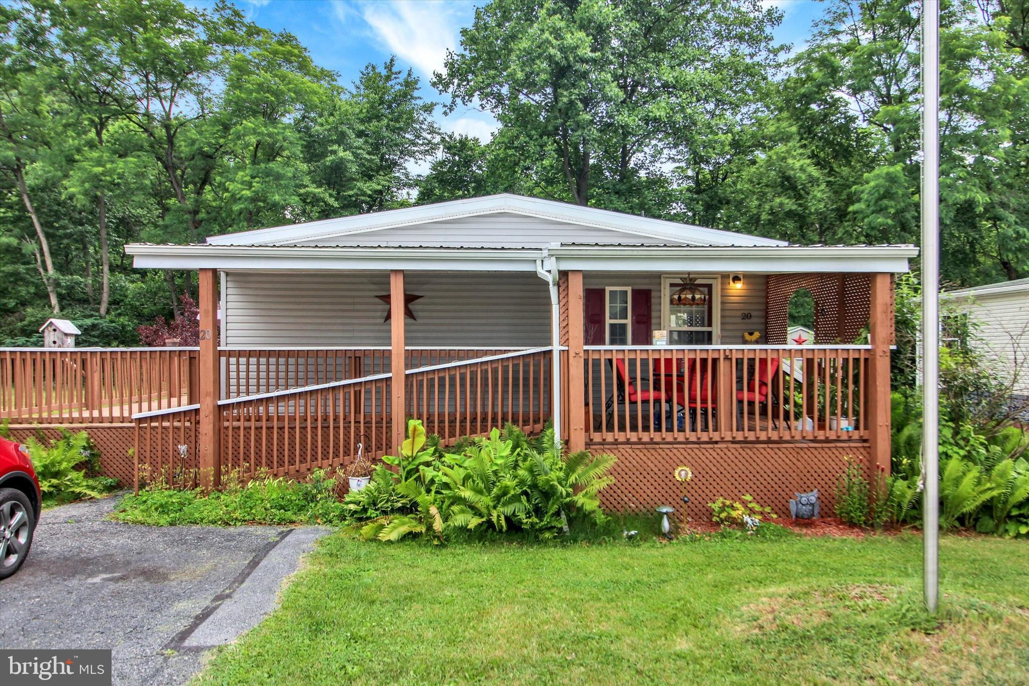 Located in the Mountain Springs community of Hamburg, PA, this beautiful single-family home was built in 2016 and is in excellent condition. The exterior was upgraded by adding a front porch and a two-sided wrap-around porch. Both entrances lead into a bright, spacious, open-concept living area with gorgeous flooring low-maintenance. The modern kitchen comes with a central breakfast island and tons of storage space. For ultimate convenience, the laundry area sits right off the kitchen, primary bedroom, and primary bathroom. The main living room opens directly to the kitchen, sits next to a full guest bathroom, and leads to two additional spacious bedrooms. Outside, the wrap-around deck connects seamlessly to the covered side porch and the yard. The property features a very large storage shed, a covered utility port, and private parking for two cars, plus extra parking out front. The property overlooks an endless view of trees, and personal mailboxes are located just one street away. The resort-style community offers excellent amenities, including a huge pond, a children's playground, and walking trails.