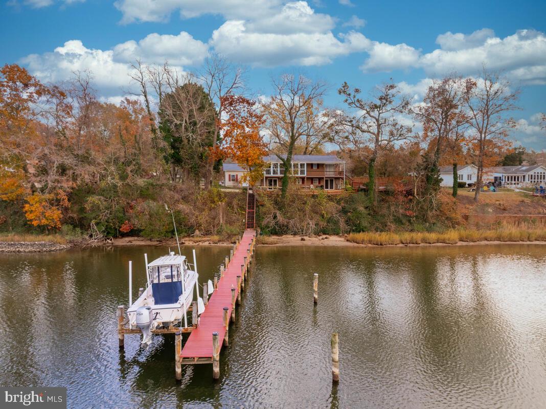Welcome to this beautifully maintained waterfront split-foyer home nestled on 1.15 private acres in a sought-after water-access community. Designed for comfort, leisure, and waterfront living, this property offers the perfect blend of indoor charm and outdoor enjoyment.

Step inside to find 4 spacious bedrooms and 3 full bathrooms, including a newly finished lower level featuring a cozy propane fireplace—ideal for relaxing evenings or entertaining guests. The main level flows comfortably with an open feel, filled with natural light and well-maintained finishes throughout. A dedicated laundry room, water filtration system, and plenty of storage—including an oversized two-car garage with attic storage plus an additional house attic—add to the home’s convenience.

Outside is your own private oasis. Enjoy summers in the inground gunite pool, complete with a Loop-Loc safety cover system. Stroll down to your private pier with boat lift, perfect for boating, fishing, or taking in peaceful views of Battle Creek.  Do you enjoy fishing?  Only minutes away right around the bend is the Patuxent River offering the chance to catch the "big" one or to stop off at the numerous waterside restaurants.  Battle Creek is one of the few that allow a wake zone, which means you can water ski or tube.   Also, in 2026 a brand-new community pier from pilings, stringers and decking boards, giving you even more opportunity to enjoy life by the water.

With a new roof in 2024, this home is truly move-in ready and built for years of enjoyment. Whether you're seeking a serene retreat, a place to entertain, or a waterfront lifestyle, this property checks every box.

Don’t miss your chance to own this rare, amenity-packed home in a premier waterfront neighborhood—schedule your private tour today!