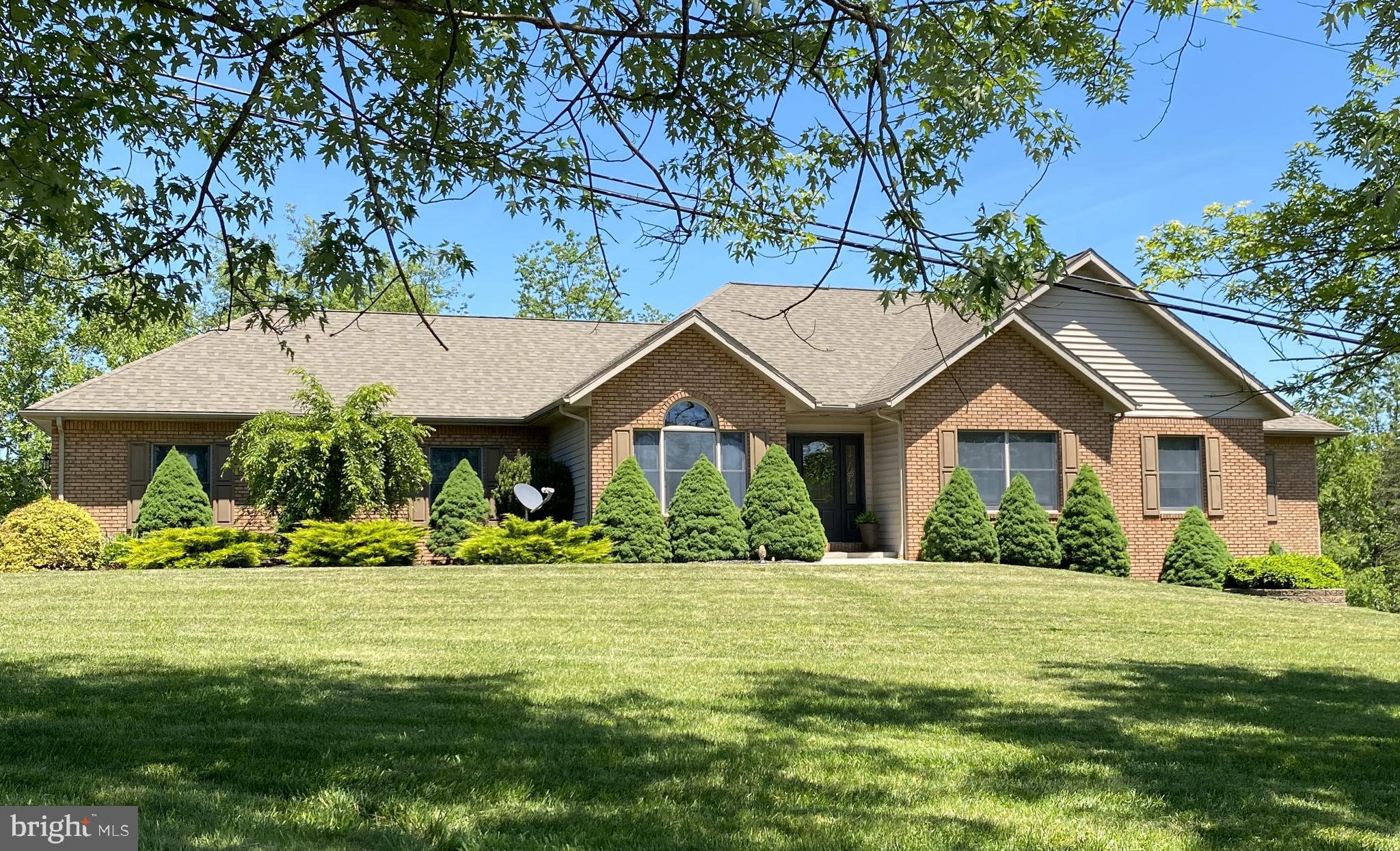 Discover your perfect sanctuary with this charming one-story brick-front home nestled on nearly 3 acres of thoughtfully wooded land.  The spacious open floor plan welcomes you with inviting living spaces, highlighted by a cozy gas fireplace.  Step outside to a large outdoor entertaining area, partially covered, ideal for gatherings and enjoying nature.  This home offers four generously sized bedrooms and two full bathrooms, with plumbing already in place for a third bathroom in the basement—perfect for future expansion. The primary suite provides private access to the outdoor deck, a large walk-in closet, and a luxurious ensuite featuring a double vanity and shower.  The finished basement boasts a sizable family room and abundant storage, providing comfort and practicality.  The paved driveway leads to a two-car garage, which conveniently opens into the first-floor laundry room.  Whether you're seeking tranquility, space for entertaining, or room to grow, this property seamlessly combines country charm with modern comforts.  Call Today for a Tour!!!