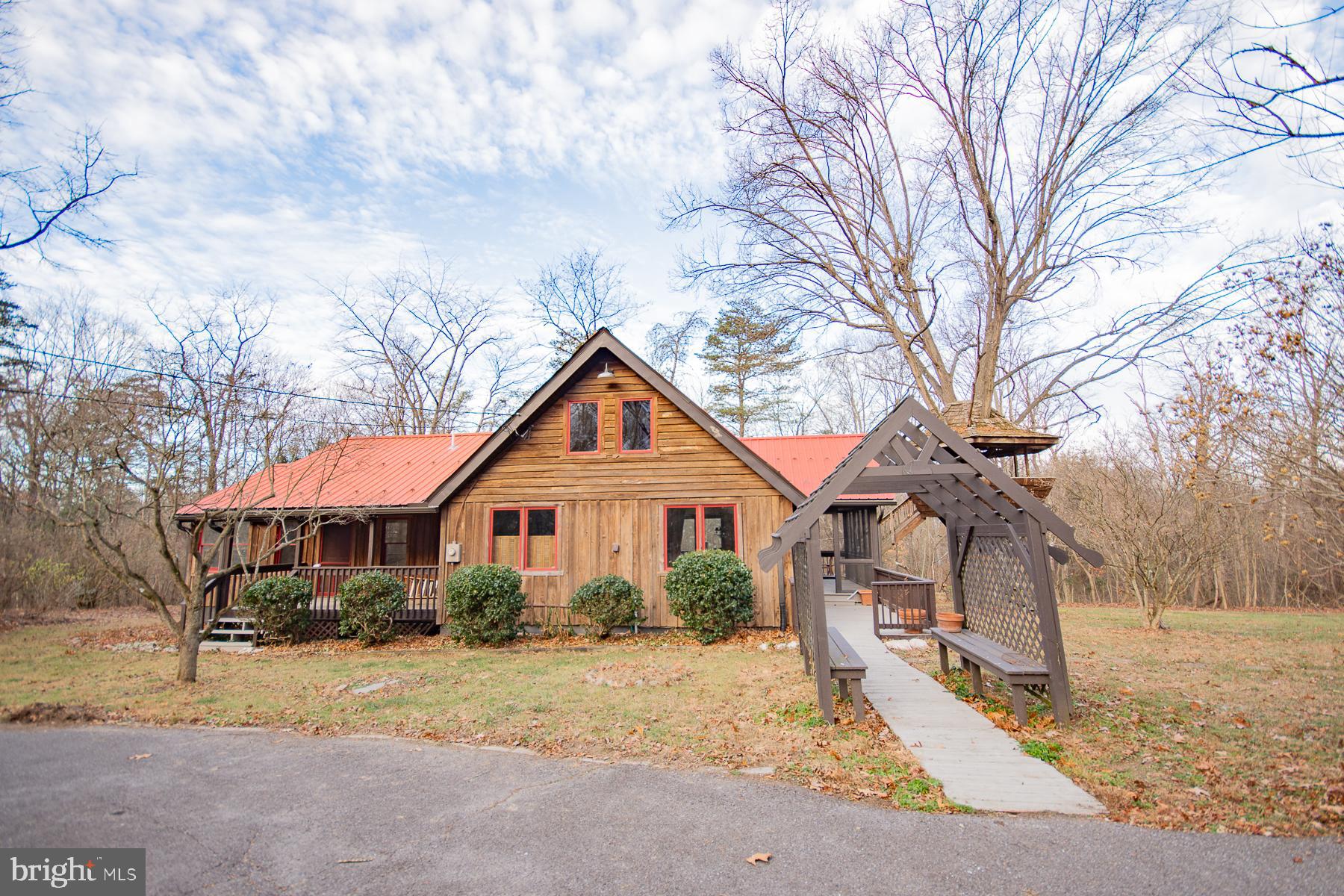 Escape to Your Perfect Retreat in Montevello Hills!  Nestled on 4.31 acres of serene countryside, this charming Chalet-style home is a haven for nature lovers. With 2 bedrooms, 1.5 baths, and 1,366 square feet of living space, this home offers cozy comfort with a touch of rustic elegance. The great room steals the show with vaulted wood ceilings, built-in bookcases, and a cozy woodstove. Picture yourself relaxing with a good book or hosting gatherings in this inviting space!  The kitchen is a cook’s delight, featuring stainless steel appliances, a stylish bar area, and an open flow for easy entertaining. Upstairs, a loft adds charm and flexibility—perfect as an office, reading nook, or extra sleeping area. With a brand-new heat pump, you’ll enjoy year-round comfort.  Step outside to discover the magic—Fenced in yard, expanded two-tier decks (complete with a treehouse!), a screened porch, and a front porch that’s perfect for sipping your morning coffee. The property boasts a tranquil pond, a greenhouse, a circular driveway, and a 2-car oversized garage with an electric-equipped tool shop. For animal enthusiasts, there are 6 kennels and coops ready for your furry and feathered friends.  Conveniently located just 10 miles from I-81 and close to Maryland and Virginia, this property combines peace and accessibility. Whether you’re looking for a private escape or an outdoor enthusiast’s paradise, this home delivers.  Don’t wait—schedule your private tour today and unlock the potential of this one-of-a-kind property!