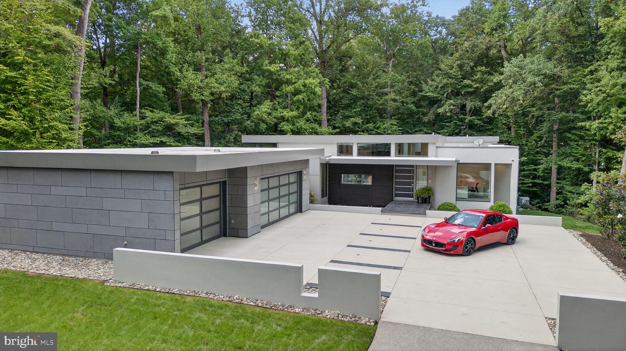 A rare fusion of innovation, design, and luxury– a cutting-edge architectural residence nestled within the gates of Kingsmill, Williamsburg’s premier Resort community. Framed by mature woodlands and tucked into a private terraced lot, the home flows effortlessly across its modern open floor plan, elevated throughout by 8’ Marvin Modern Collection windows. The gourmet kitchen is appointed with top-of-the-line Miele appliances, gorgeous stone countertops and sleek custom cabinetry. Retreat to a serene primary suite with custom closets and spa-inspired bath. Two additional bedrooms share another ensuite bath on the main level with a private office off the front entrance. A screened porch, terrace, and firepit make this home perfect for entertaining. The lower level features a stunning cantilevered staircase, wet bar and recreation room and a state of the art home theater that delivers a true cinematic experience. A fourth bedroom is easily used as a home gym or flex space with a conditioned mechanical room and an immaculate crawl space. Beyond the aesthetics lies an infrastructure few homes can match. Live in sophistication—surrounded by privacy, nature, and resort-style amenities.