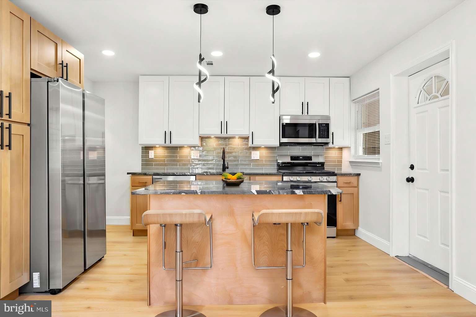 Rarely does a city property offer this level of privacy, outdoor space and off-street parking. Combining modern finishes, generous room sizes, and an exceptional outdoor setting, this Holmesburg gem truly stands apart from the rest. A high privacy fence fully encloses the expansive patio area, creating an outdoor retreat with approximately 200 square feet of additional living space. Whether you're entertaining guests, enjoying time with pets, or creating a safe place for little ones to play, this versatile outdoor area is sure to impress. The fenced space also includes convenient off-street parking. Inside, you'll find a bright and inviting home filled with natural light. The stunning kitchen features two-tone shaker cabinetry, designer black granite countertops, a custom glass tile backsplash, and high-end stainless steel appliances. The main level also offers a spacious living room and a stylishly updated powder room. The full finished basement provides valuable additional living space along with laundry and a garage that has been converted to a storage room. (storage room can be converted back to a garage). Upstairs, you'll find three generously sized bedrooms and a beautifully renovated full bathroom featuring a custom tile shower. Offering a rare combination of privacy, outdoor living, off street parking , modern updates, and city convenience, this one-of-a-kind Holmesburg home is ready for its next owner.