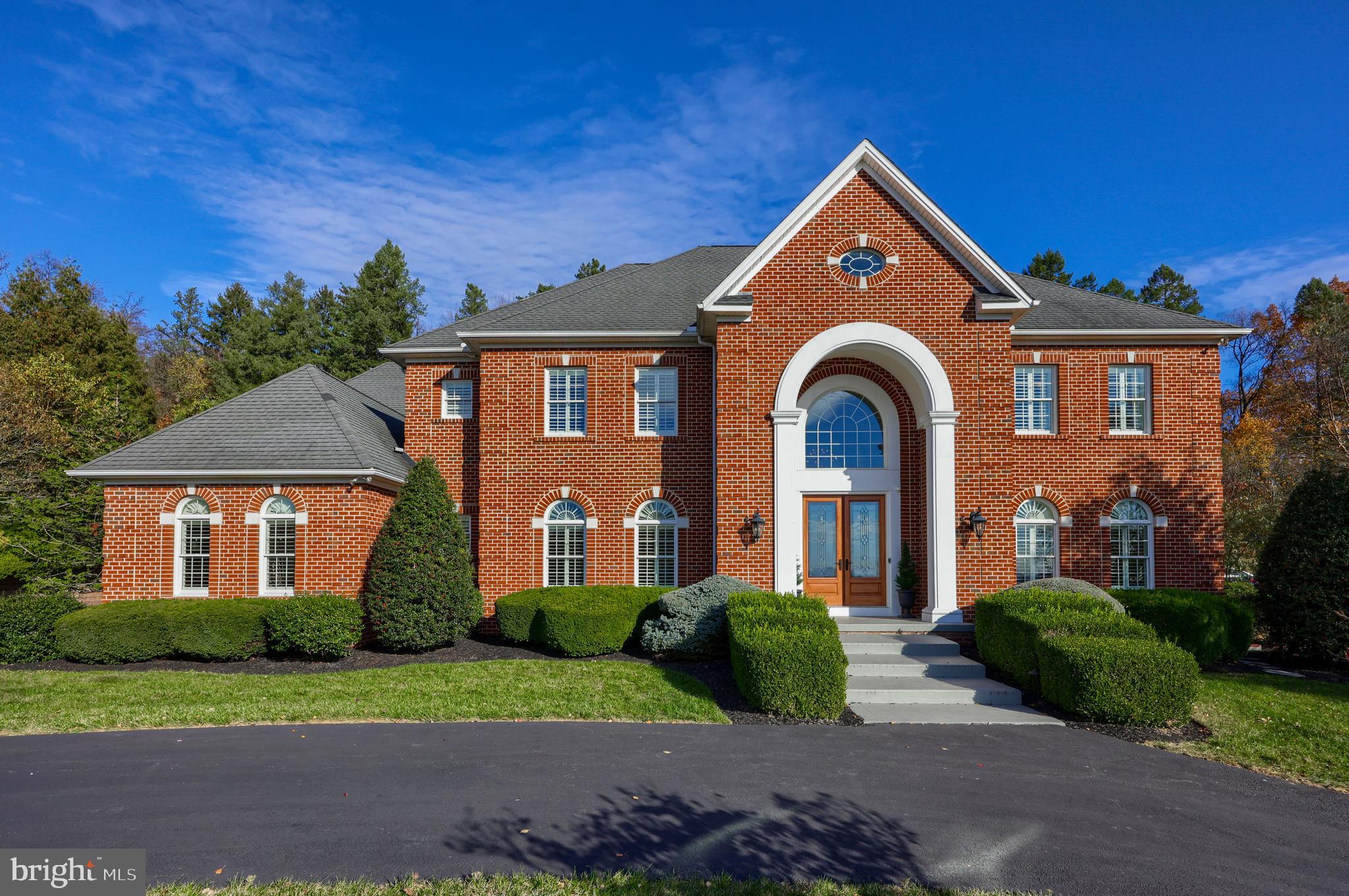 Experience the epitome of luxury living in this stunning residence located in the desirable Wyndham Hills South neighborhood, now ready for its new owners. This home, meticulously crafted with no expense spared, features custom cabinetry and exquisite updates, seamlessly blending elegance and practicality. The spacious layout is filled with high-quality finishes and thoughtful design elements, ideal for contemporary living. With eight generous bedrooms, five full bathrooms, and two half baths, there’s ample room for relaxation and entertaining. The striking all-brick exterior and inviting circular driveway create a memorable first impression. Step inside to a grand two-story foyer, where a curved custom wood and iron staircase welcomes you. The formal dining room, adorned with wainscoting and a chandelier, and a cozy sitting room accessed through French doors exude sophistication. The expansive family room, highlighted by soaring windows, a coffered ceiling, and a warm gas fireplace, invites natural light and comfort. Imagine cooking in your gourmet kitchen, with custom cabinetry, beautiful granite countertops, high-end appliances, and a spacious walk-in pantry, making it perfect for entertaining. Practical features such as a first-floor laundry room and mudroom enhance everyday convenience. The oversized four-car heated garage is equipped with electric car outlets, cabinetry, and a sink, plus direct access to the finished lower level. The upper-level primary suite offers a serene retreat, featuring a cozy sitting area, a tray ceiling, two walk-in closets, and an en-suite bathroom that boasts dual vanities, a jetted tub for ultimate relaxation after a long day, and a separate water closet. This level also offers three additional bedrooms—one with its own en-suite bathroom and two sharing a thoughtfully designed jack-and-jill bathroom. The lower level is equally impressive, featuring a kitchenette with an island, a recreation/theater room perfect for gatherings, two bedrooms, a full bath, and ample storage. Outside, brick patios and tiered landscaped areas provide breathtaking views, while a commercial-grade internet system ensures excellent connectivity throughout the home. Don’t miss the opportunity to make this extraordinary property your own!