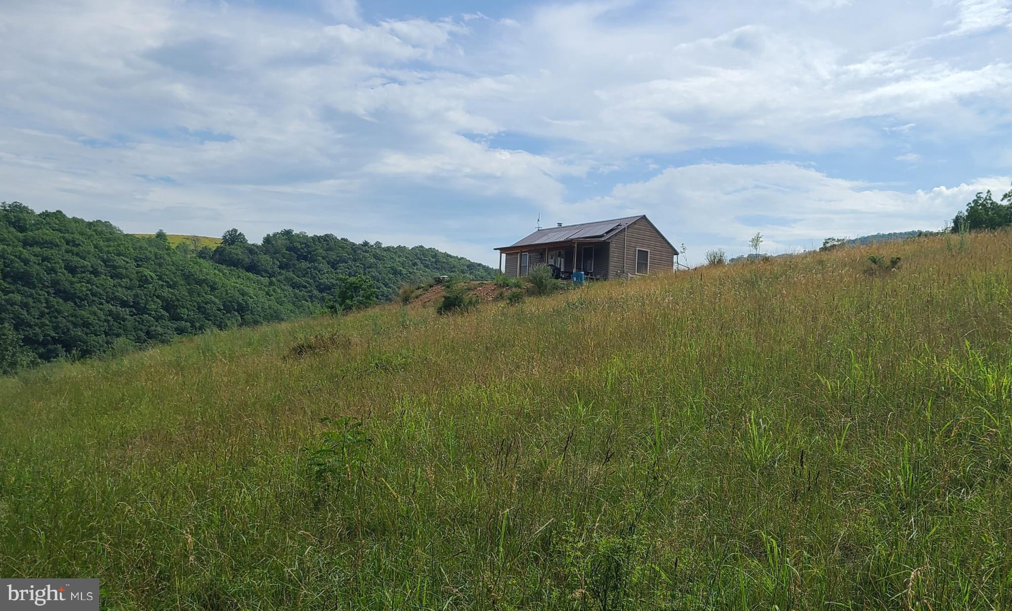 Secluded Cabin with Panoramic Views!  Immerse yourself in nature where you'll find lots of wildlife, recreation and plenty of room to play with targets already in place for target practice. This "off the grid", run by pure solar, one bedroom, one bath rustic cabin has a spacious loft for extra sleeping and couldn't be in a more perfect setting for a little R & R.  The Mini-Splits and cozy wood stove keep the temperature just right all year round. The efficiency kitchen has all you need for hunting trips or getaways. 12 x 24 storage building behind the cabin. Use it for storing extras or turn it into a bunk house!