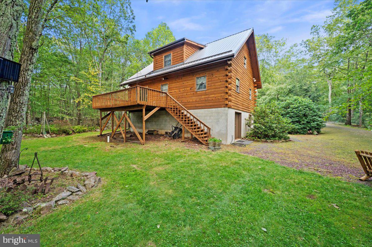 This is not just a home. It’s a private Pocono compound built for those who need space to build, store, create, and escape. Set on over 6 wooded acres within Hickory Run Forest, this property delivers a rare combination of land, infrastructure, and flexibility that is nearly impossible to replicate in today’s market. The centerpiece is a $200,000+ Amish-built 60x40 detached garage and workshop designed for serious use. Featuring three oversized bays, full concrete flooring, electric, extensive lighting, built-in workbenches, utility sink, and a finished upper-level loft, this space is ideal for contractors, car collectors, hobbyists, or anyone seeking a true live-work environment. Whether you're storing equipment, working on projects, or creating a private retreat for your passions, this structure defines the property. The main residence is a handcrafted log home offering authentic mountain character and a warm, lodge-style atmosphere. Inside, vaulted ceilings, exposed beams, and tongue-and-groove woodwork create a timeless interior anchored by a dramatic floor-to-ceiling stone fireplace in the main living area. The open-concept layout connects the living room, dining area, and kitchen, providing a functional space for everyday living or weekend gatherings. A loft overlooks the main level, offering additional flexibility for sleeping, office, or recreational use. The walk-out lower level adds usable space for storage, workshop expansion, or recreation, while the surrounding acreage provides privacy, separation, and long-term flexibility. Multiple included parcels enhance the scale of the property and contribute to a setting that feels secluded, yet remains accessible. Located just minutes from Jim Thorpe, the PA Turnpike, and year-round Pocono attractions including hiking, skiing, and outdoor recreation, this property offers both convenience and escape. Whether used as a primary residence, second home, or a functional live-work compound, the value here is in the combination of land, usability, and infrastructure. This is a property designed for a specific buyer. Someone who understands the value of space, privacy, and purpose-built improvements. Opportunities like this are limited, and replacement cost alone makes this a compelling offering in the current market. Property is being sold as-is. Buyer to verify all measurements, parcel information, and permitted uses. Multiple tax parcels included in the sale.