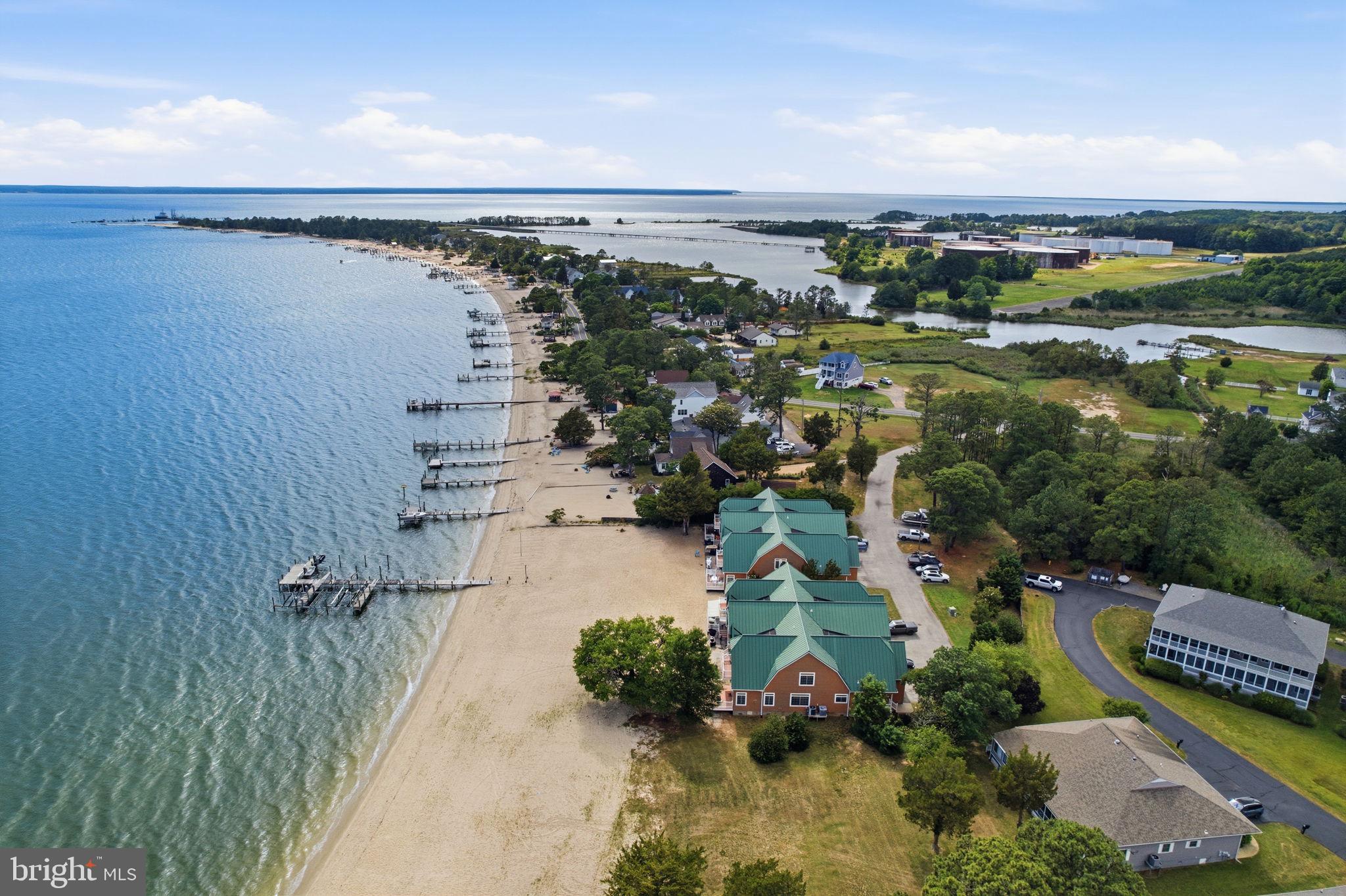 Enjoy effortless waterfront living in Southern Maryland from this premier end-unit condominium on Oakwood Lodge Lane in Piney Point, offering expansive views across the Potomac River to Virginia and a white sandy beach just steps from your door. Nestled within an exclusive 6-unit condominium community, this maintenance-free waterfront retreat offers over 3,500 square feet of beautifully designed living space with 3 bedrooms, 2 full baths, and a convenient main-level half bath.

The main-level primary suite provides comfort and convenience, while hardwood floors, a chef’s kitchen, gas fireplace, and panoramic river views create the perfect setting for everyday living and entertaining. Upstairs, you'll find an additional primary suite featuring a private balcony overlooking the Potomac River and sandy beach—an ideal spot to enjoy morning coffee, watch boats pass by, or take in spectacular sunsets. The upper level also includes a  a third bedroom, a spacious bunk room, and an additional full bath, providing plenty of room for family and guests.

Step outside and sink your toes into the sandy beach, launch your boat from your deeded slip equipped with a 12,500-pound boat lift, or relax on the expansive deck overlooking the river, beach, and community pier. An attached 2-car garage provides ample storage for vehicles and beach gear. For boating enthusiasts, the property is located just minutes from the mouth of the Potomac River and approximately 15 minutes by boat from the Chesapeake Bay, providing easy access to some of the region's best fishing, cruising, and waterfront destinations.

Located within walking distance of the Piney Point Lighthouse Museum, this exceptional waterfront residence offers a rare opportunity to enjoy one of the finest waterfront lifestyles in Southern Maryland, where boating, fishing, beach days, and unforgettable sunsets become part of everyday life.