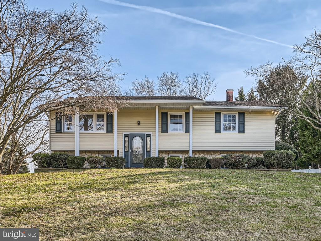 Expansive 3BR/1.5BA Split Foyer home located in a desirable neighborhood.  This home sits on an oversized lot and features beautiful landscaping from front to back.  The oversized driveway can accommodate your family and friends, and swings around the back to meet a large patio with a stone retaining wall. Stately columns and a covered front entry greets you as you open the door into your forever home.  Step into a two-story foyer with stairs leading up to the main living spaces, and down to additional space for your family to enjoy.  On the main floor is a large open concept living room and dining room, both beaming with tons of natural light.  An eat-in kitchen offering plenty of cabinets with a separate pantry closet, a generous amount of counter space, and two windows with a stainless sink below. Down the hall are two sizable secondary bedrooms, a full bath, and a large owner's bedroom.  Just off the dining room is a bonus space ideal as an office space with access to a large wood deck that overlooks the yard.  The lower level is finished, featuring a large family room with a wood burning fireplace flanked by a stone facade, a built-in bar area, a half bath, a large laundry space, storage, and sliding doors to a stunning yard. The yard is surrounded by adult trees and filled with tons of green space.  This home is move-in ready and has so much to offer any new homeowner.  Imagine all this and in close proximity to shopping, restaurants, and commuter routes.