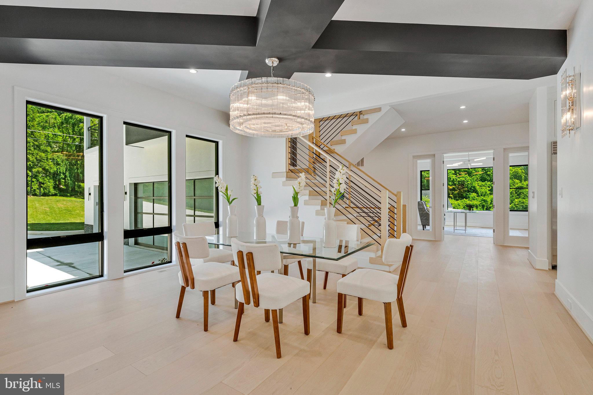 Nestled on an exceptionally rare flat 31,533 sq ft lot in one of McLean’s most peaceful enclaves, this extraordinary custom residence redefines modern luxury with resort-inspired living and timeless architectural sophistication. Surrounded by mature trees and backing to a serene creek, the property offers remarkable privacy and picturesque natural views, creating a true retreat just minutes from the heart of the city.
Designed to impress from the moment you arrive, the home showcases a striking stucco exterior, expansive walls of glass, and a spacious three-car garage that perfectly complement its sleek contemporary design. The expansive level backyard offers endless possibilities — from a future resort-style pool to a private sports lawn — all easily enjoyed from the comfort of the covered screened porch.
Inside, soaring 10-foot ceilings on every level and wide-plank prefinished oak hardwood flooring create an airy, elegant ambiance throughout. Refined finishes include solid 8-foot modern doors, designer lighting, and seamless indoor-outdoor living spaces crafted for both everyday comfort and elevated entertaining.
The heart of the home is an impressive open-concept family room anchored by a dramatic floor-to-ceiling linear gas fireplace. Just beyond, the screened porch features metal-framed screens and its own gas fireplace, offering the perfect year-round setting for gatherings, dining, or quiet evenings overlooking the wooded landscape.
The luxurious primary suite serves as a private sanctuary, complete with a cozy gas fireplace, Juliet balcony, and secluded terrace with tranquil backyard views. The spa-inspired ensuite bath elevates daily living with heated floors, sophisticated finishes, and a calming retreat-like atmosphere.
Each upper-level bedroom is thoughtfully designed as a private ensuite, featuring custom walk-in closets, marble-topped vanities, and beautifully appointed bathrooms that blend elegance with functionality.
The fully finished walk-out lower level continues the home’s exceptional design and livability, featuring soaring ceilings, oversized windows, and abundant natural light. Highlights include an expansive recreation room with a custom wet bar, rich wood accents, ambient lighting, and a stunning stone fireplace. A dedicated media room with tiered seating delivers an immersive cinematic experience, while the fitness room with adjacent full bath offers ideal flexibility for wellness or guest accommodations.
Perfectly positioned near downtown McLean, acclaimed schools, upscale shopping and dining, and major commuter routes, this remarkable residence offers the ultimate balance of luxury, privacy, comfort, and convenience.