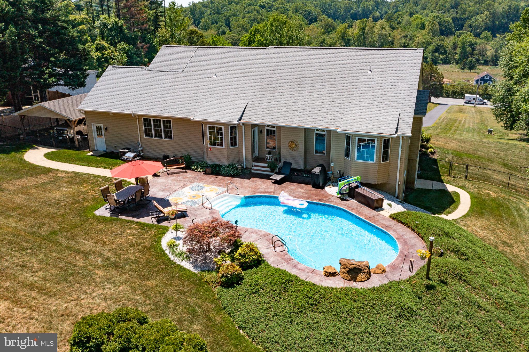 Beautifully maintained custom home on 1.94 private acres located in La Plata, just one mile west of the town center—offering a rare combination of privacy, space, and convenience with approximately 4,300+ square feet of finished living space, including a fully finished basement. Built in 2008, this impressive residence features an open, light-filled layout with hardwood flooring throughout the main level, a dramatic cathedral-ceiling living room, and a striking floor-to-ceiling gas fireplace. The spacious eat-in kitchen is ideal for everyday living and entertaining, complete with a breakfast bar, bay window, computer nook, and generous table space, plus a separate formal dining room. The main-level primary suite provides a private retreat with a bay window, spa-like en-suite bath with double vanities, glass-enclosed shower, and jacuzzi tub, and a professionally designed custom closet installed in 2021. A second main-level bedroom with a large walk-in closet and a full hall bath adds flexibility and convenience. The finished basement offers a large recreation/family room, an additional bedroom, full bath, and extensive storage—perfect for guests, hobbies, or multi-generational living. Outdoor living shines with a private in-ground pool (liner replaced 2023), spacious patio, fully fenced backyard with double gate access, and beautifully landscaped grounds designed for seasonal color, plus a horseshoe pit for added enjoyment. Car enthusiasts will appreciate the 3-car garage and additional carport, including a gas heater hookup in the double bay. Additional highlights include a heat pump with 500-gallon in-ground propane backup, interior and exterior security system with driveway alarm, large storage areas throughout, a regularly maintained asphalt driveway, 6-inch gutters with guards, and a roof-mounted solar system for enhanced efficiency. Major updates completed in 2020 include New Roof, New HVAC system (inside and out), New hot water heater, microwave, and pool pump, with the dishwasher replaced in 2024. No HOA, No front foot fees and no school excise tax!

This exceptional property offers the perfect blend of indoor comfort and outdoor enjoyment—all in a convenient La Plata location.