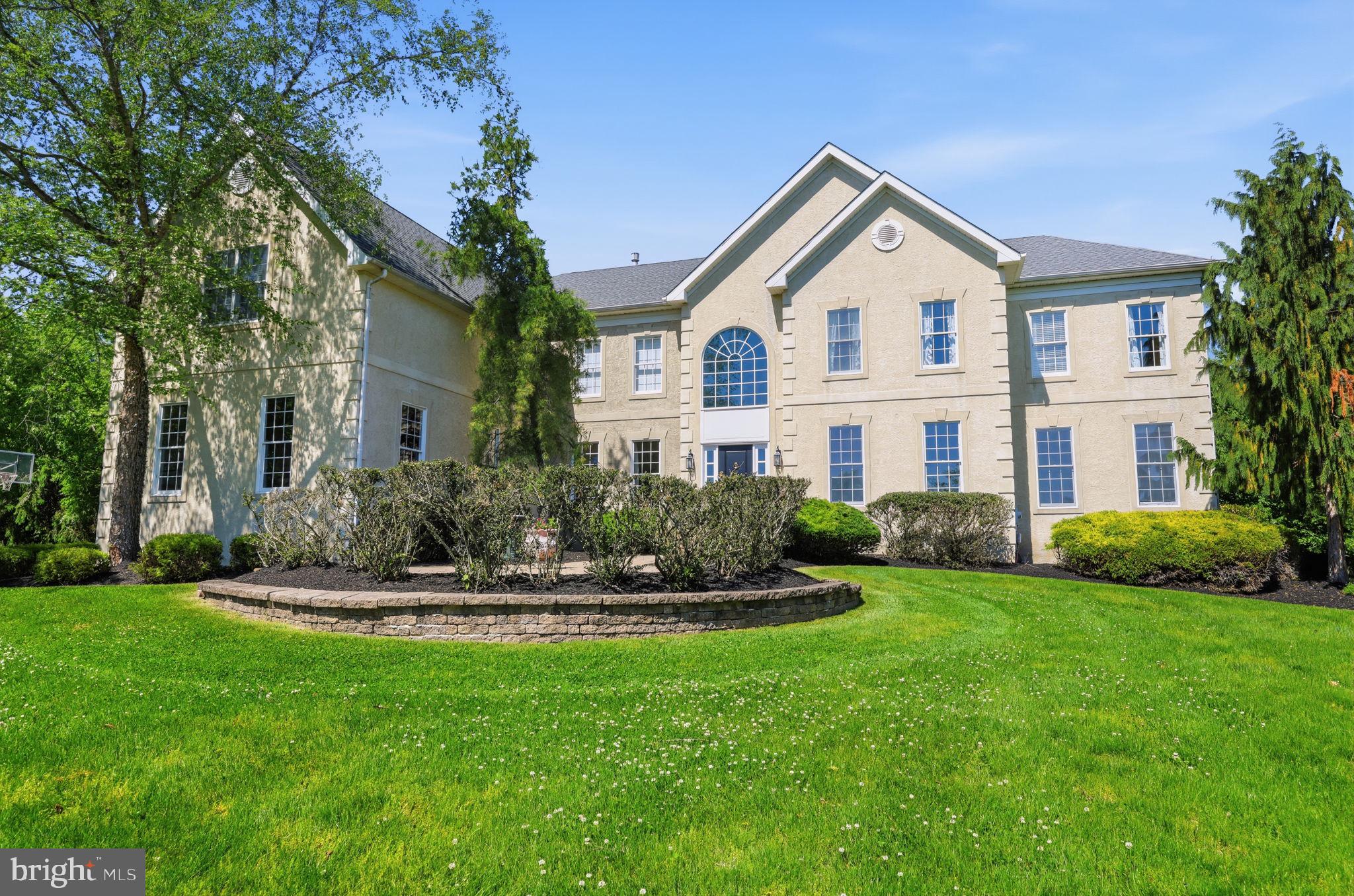 Welcome to this stately executive residence nestled within a small, highly sought-after community neighboring Jericho National Golf Club and Brownsburg Park. From the moment you arrive, the home exudes timeless elegance and old-world craftsmanship, beginning with the tree-lined approach leading to the side-entry 3-car garage featuring durable rubber tile flooring.

A dramatic two-story foyer welcomes you inside, highlighted by a sweeping curved staircase and impressive architectural detail throughout. Designed for both everyday living and grand entertaining, the spacious kitchen offers an abundance of cabinetry and drawers, stainless steel appliances, wall oven and microwave, and a large island with breakfast bar seating and gas cooktop.

The adjoining breakfast nook opens to an extraordinary outdoor living space featuring a fabulous slate and brick patio complete with a built-in grill, sink, outdoor kitchen, and multiple seating areas large enough to host memorable gatherings. Mature trees surrounding the corner homesite create a peaceful, semi-private retreat.

Hard surface flooring flows throughout the main living areas. The spectacular two-story family room showcases a full wall of windows, a gas fireplace, built-in shelving and TV nook beneath the staircase, and a secondary staircase overlooking the room below. The main level also features a formal living room connected to a spacious second family room, a private office, and an elegant formal dining room accented with classic wainscoting.

Function meets convenience in the thoughtfully designed laundry room featuring cabinetry, utility sink, window, exterior access to the garage side yard, and connection to the garage entry with space for a mudroom setup.

Double doors lead to the luxurious primary suite complete with a sitting area, 2 walk-in closets with the primary bath having dual vanities, separate walk-in shower, and a generous soaking tub designed for relaxation. Three of the five bedrooms enjoys the privacy and convenience of its own attached full bathroom and walk-in closet and bedrooms 4 and 5 share a jack and jill bathroom.  

Additional features include a full unfinished basement offering endless possibilities for future expansion and a striking stucco exterior with a Venetian plaster appearance accented by decorative coin detailing, adding to the home's sophisticated curb appeal.

This exceptional property combines elegance, comfort, and functionality in one truly remarkable home.
