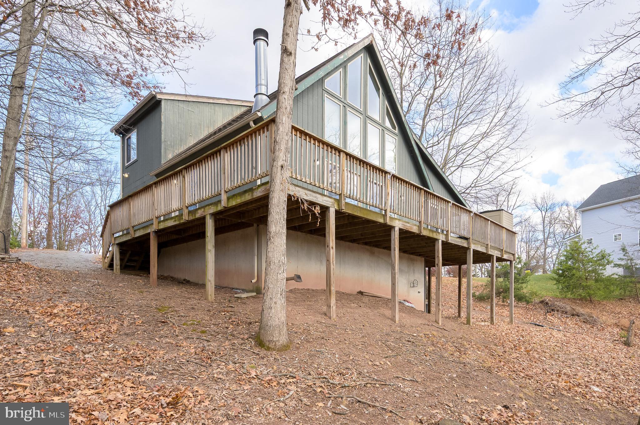 Escape to the mountains and enjoy beautiful views from this charming chalet-style home tucked away on 0.75 wooded acres. Inside, the bright great room features soaring cathedral ceilings with exposed wood beams, a wall of windows, and a cozy wood-burning fireplace—perfect for relaxing after a day outdoors. The open layout flows into the dining area with sliding glass doors that open to a spacious wrap-around deck and a screened-in porch, ideal for morning coffee or evening gatherings surrounded by nature.
The kitchen offers updated lighting and newer Samsung stainless steel appliances. The loft-style owner’s suite provides a peaceful retreat with a private bath, whirlpool tub, and generous walk-in closet. A finished walk-out basement adds extra space for entertaining or guests, complete with a recreation area, full bath, pellet stove, and laundry room.
Additional highlights include a whole-house generator, two storage sheds. Well-maintained and move-in ready, this home is perfect as a full-time residence, weekend getaway, or mountain retreat.