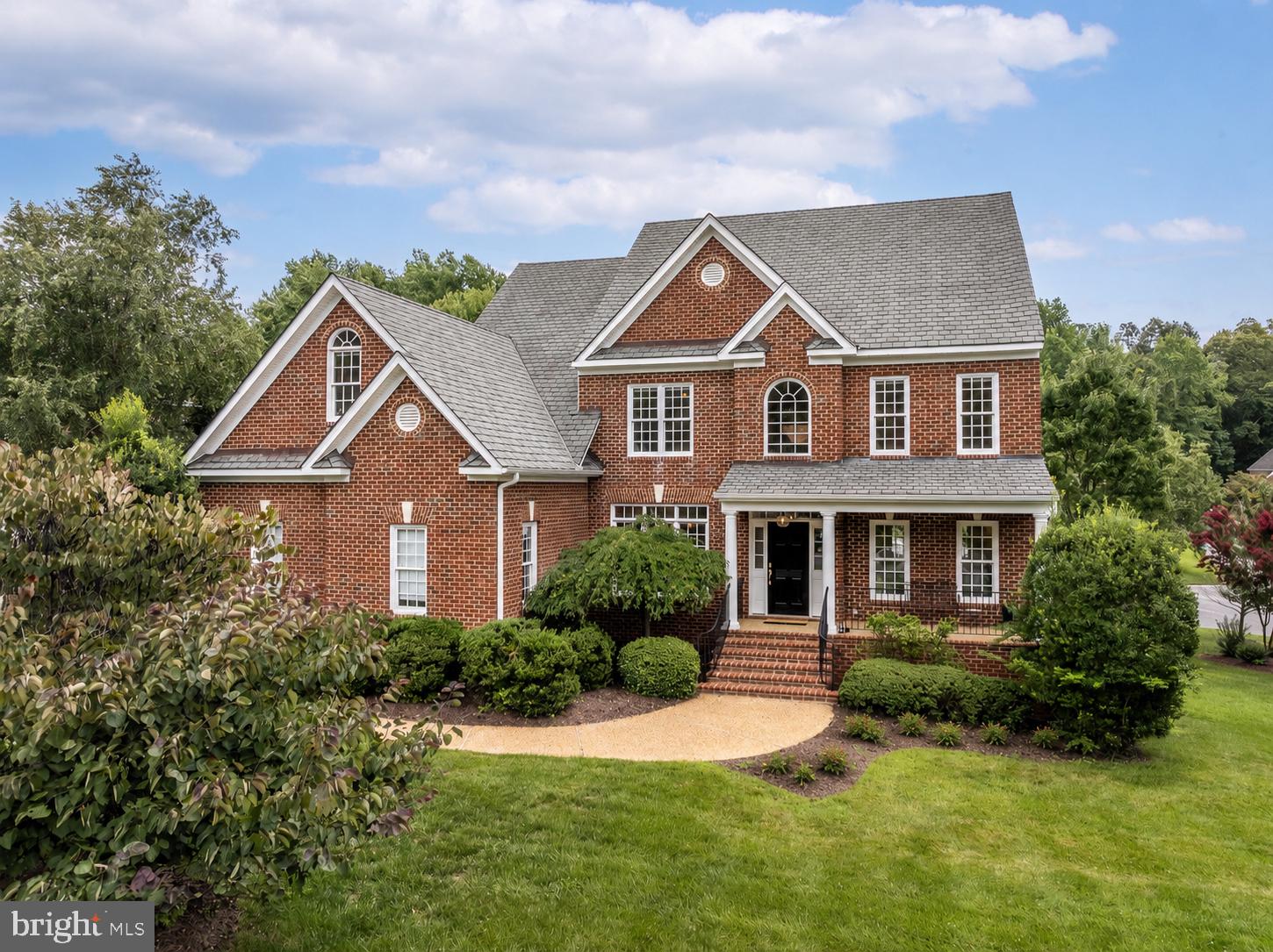 This stunning brick transitional home, lovingly cared for by its original owner, is situated on a beautifully landscaped ¾-acre lot abutting a quiet cul-de-sac. This home pairs impressive curb appeal—complete w/a grand manor roof & covered front porch—with a fresh, modern aesthetic and exceptional flow. Step into a 2-story grand foyer featuring 17-ft ceilings, 3-member crown molding and a beautiful Shades of Light custom fixture. The main level offers a LR/office space, a formal DR, a large laundry room, & refinished HDWD floors paired w/fresh white paint for a bright, cohesive feel. The gourmet kitchen is bathed in natural light, boasts new quartz tops & backsplash, an expanded island, a new gas cooktop w/pot filler, new Shades of Light fixtures, and a walk-in pantry. A wine & coffee bar w/built-in wine fridge makes entertaining fun! The adjoining spacious FR features surround sound & a cozy gas fireplace. The kitchen opens to a spacious screened-in porch w/skylights, offering a seamless transition to outdoor living. Upstairs, find new HDWD floors & 4 spacious bedrooms w/3 full baths. The primary suite is a retreat w/triple crown molding, an expansive WIC, and a spa-like bath w/dual vanities, quartz counters, jetted tub & updated shower. Three bedrooms feature HDWD floors & WIC's, while the 4th offers cozy carpet & a window seat. All bathrooms have been updated w/new cabinetry, quartz tops, modern plumbing & light fixtures. The finished walk-out basement is ideal for hosting guests, featuring a large rec room w/gas fireplace, an add'l bedroom w/bath & a storage room which can be converted into a kitchenette to create an in-law suite. French doors lead out to a covered patio overlooking the quiet, private backyard. Storage is aplenty with an oversized 2-car garage, an attached storage room, an exterior shed, and an enormous, walk-up attic w/4 ft-wide stairs—ready future living space, if desired. Two new Trane HVAC systems (2024/2026) & an MOEN Smart Water Shutoff System gives you peace of mind for years to come!