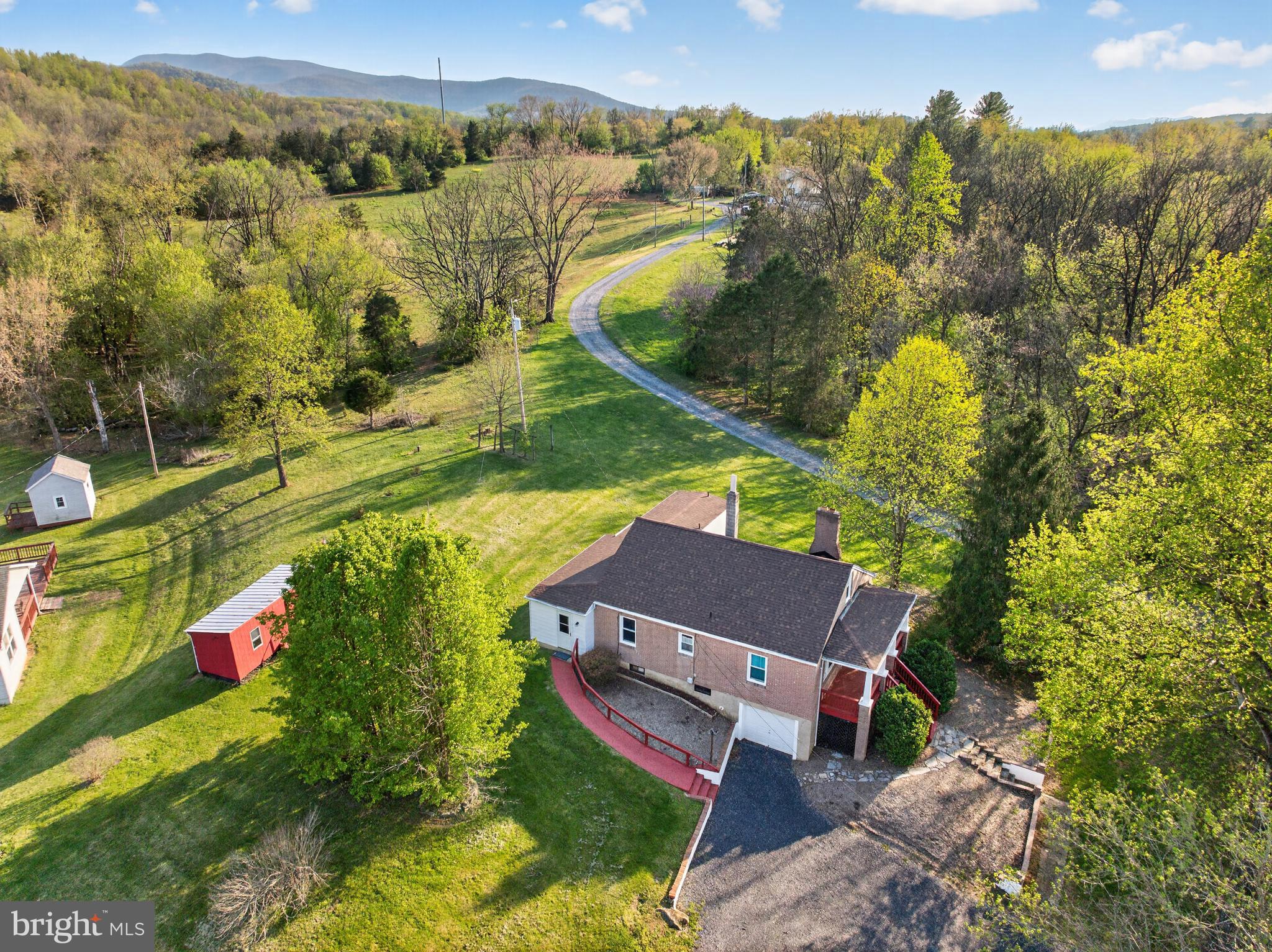 Charming brick Cape Cod offering nearly 1,500 finished square feet on a picturesque 1-acre lot with stunning mountain views. Conveniently located just minutes from Front Royal on paved roads, this property combines peaceful country living with easy commuter access to I-66.

Recent updates include a new roof (2023) and hot water heater (2025). The home welcomes you with a covered front porch—perfect for relaxing and taking in the scenery.

The main level features two bedrooms, hardwood flooring, a cozy family room with a brick wood-burning fireplace, and convenient main-level laundry. The kitchen includes a breakfast area and easy access to a versatile enclosed rear porch—ideal for year-round enjoyment, entertaining, or additional living space.

Upstairs, you’ll find an additional bedroom and full bath, offering privacy and flexibility. The full unfinished basement provides excellent potential for future expansion.

Additional highlights include a 1-car attached lower-level garage and a large detached garage, perfect for a workshop, storage, or hobby space.

Ideally situated near the Shenandoah River, Shenandoah River State Park, Skyline Drive, wineries, hiking trails, and more—this home offers the perfect blend of outdoor recreation and everyday convenience.  Property is being sold in AS IS Condition