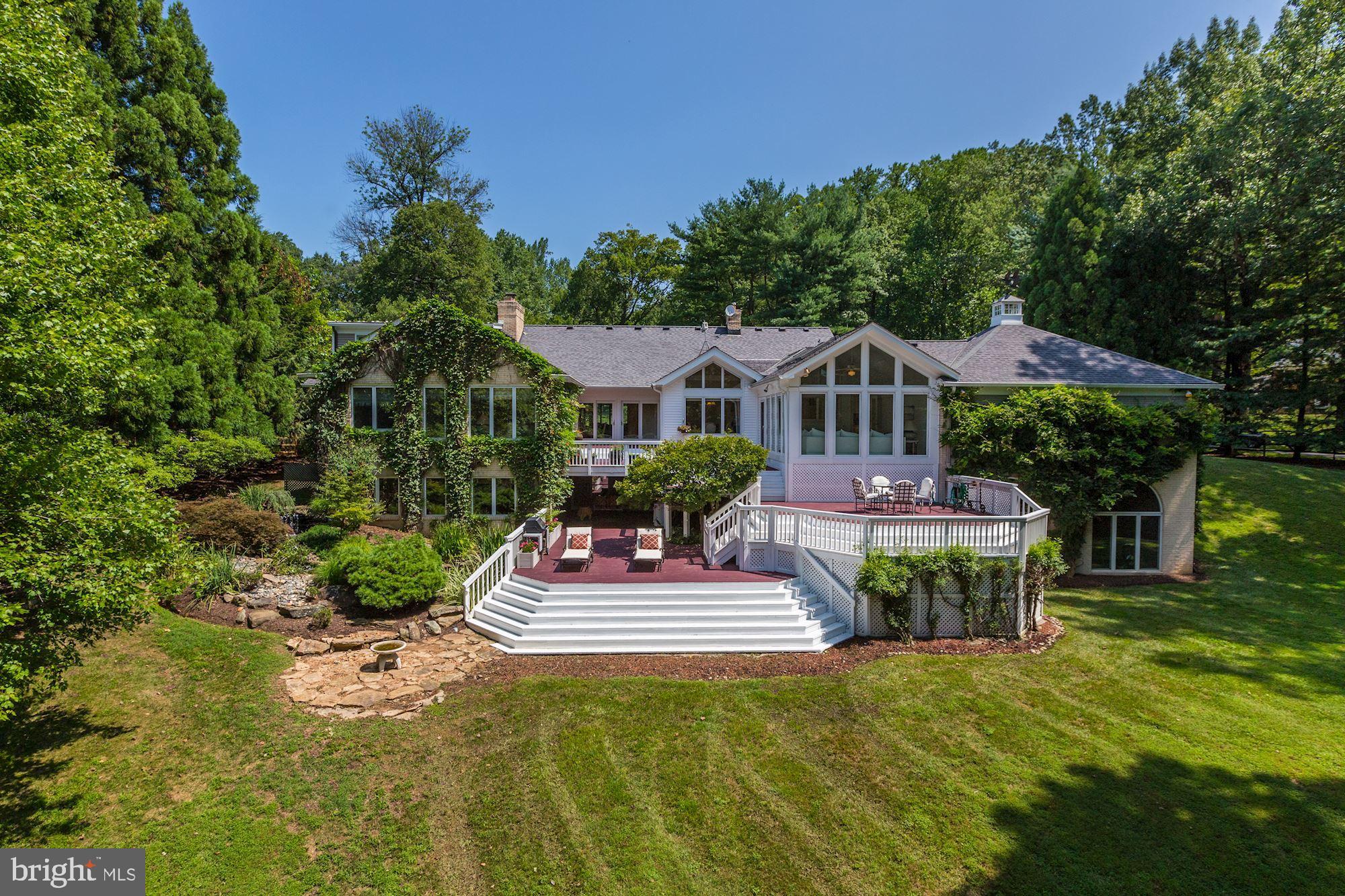 BIG PRICE REDUCTION!  Truly a must see in Potomac Falls to appreciate the value. Take the 3D tour  at  http://my.matterport.com/show/?m=wAsQD5KuiUhThis surprising gem of a home is elegant and sophisticated and sited on a coveted two-acre lot overlooking a pond. The custom-crafted interior will WOW you! The spacious entry foyer leads into a large, bright, open living room with built-in seating and a two- sided gas fireplace. The central dining room, with gas fireplace, opens to the deck and has a beautiful view overlooking the pond. The heart of the home is the beautiful, eat-in, gourmet kitchen with two ovens, two dishwashers, two sinks, a four-burner gas cook-top, beverage/wine cooler, separate ice maker, custom drawers, expansive counter space, and vaulted ceilings with skylights. The kitchen also includes a casual seating nook with built-ins and double-sided gas fireplace. Step down from the kitchen into the sunroom with a white, painted brick wall with gas fireplace and two walls of windows overlooking a tiered deck and the pond. Also off the kitchen are powder room and a large laundry / mud room which opens to the side driveway. The first-floor master bedroom suite is situated to take in the tranquil views overlooking the back yard and pond where you can see majestic blue herons cruising in over the water. The suite is further enhanced with his and her full baths and a very generously sized custom-built walk-in closet. Also on this level are a private guest bedroom and full bath.The upper-level suite is comprised of a bedroom with large walk-in closet, full bath, and a TV hide-away room with door to attic storage.The expansive walk-out lower level is finished to the same high standard as the rest of the home. High ceilings, walls of windows, and sliding glass doors to the exterior bring in loads of natural light. The family room, game room with pool table, full kitchen with bar seating, wood- burning fireplace and telephone booth make this a fun space to hang out with the family or entertain in. The magnificent home office, which was custom built with cherry cabinetry on three walls, has window views overlooking the three-tiered waterfall and lily pond, as well as bringing in the sights beyond of the sweeping yard and pond. This is not your average home office. It has a large, central-island desk space where two people can easily work. Adding to the fun factor of this lower level is a home theatre room with built-in screen and projector and a home gym you will want to work out in. The amazing gym space has floor to ceiling Palladian windows overlooking the back yard and pond. It is large enough for any and all equipment and the high ceilings, exposed brick walls and pendant lights give it an industrial like feel. Don t miss the gaming room, sure to be the envy of every gamer. This could also be used as a storage room. Rounding out the lower level is a full bath. VIEW the 3D TOUR http://my.matterport.com/show/?m=wAsQD5KuiUh