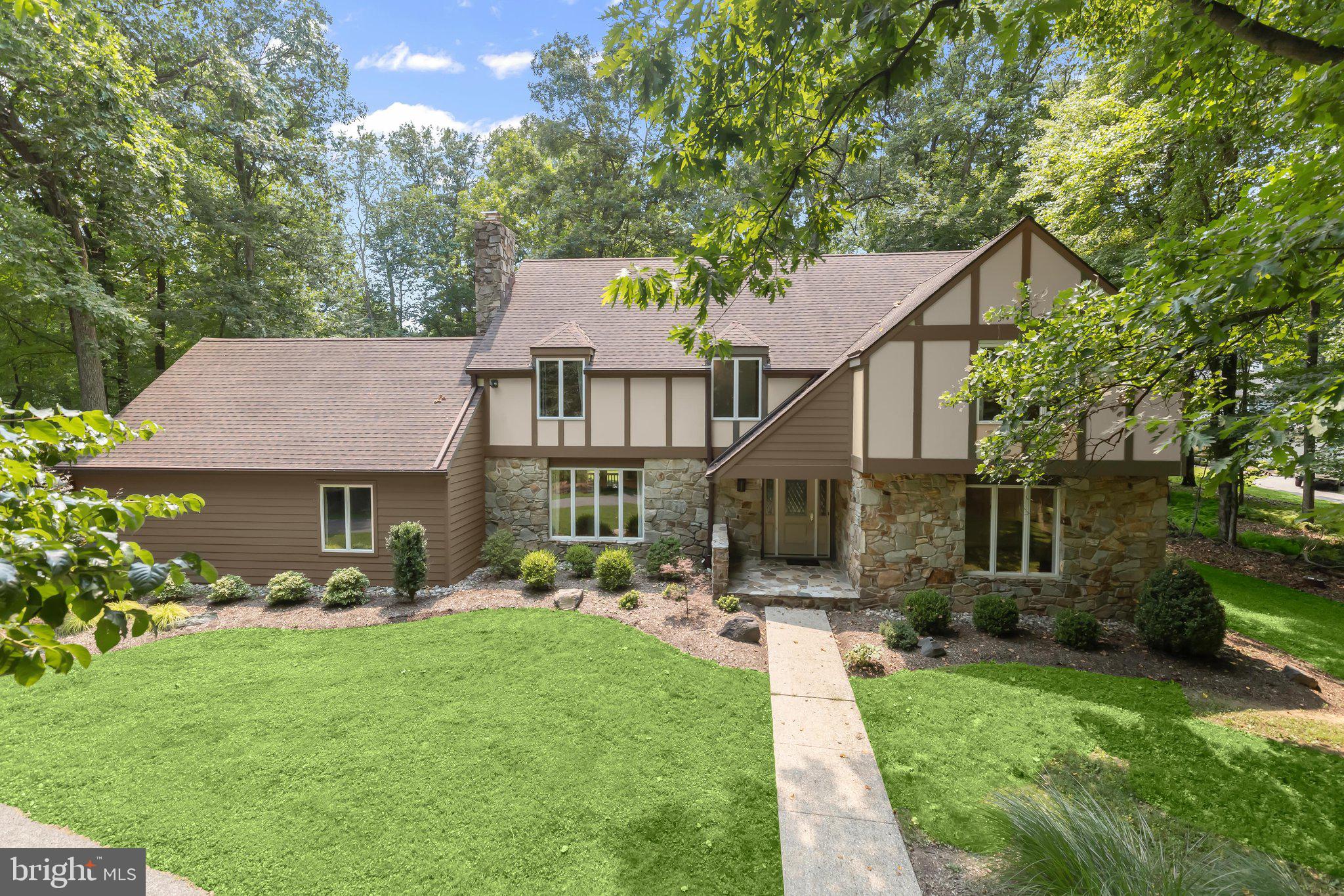 Nestled on a picturesque 1.26-acre homesite in the sought-after Pinewood Farm community, this exceptional Tudor-style residence offers timeless architecture, refined finishes, light-filled interiors, and an idyllic setting surrounded by mature trees. Boasting four spacious bedrooms, four full baths, and a powder room, this home is thoughtfully designed for elegant entertaining and comfortable everyday living. A welcoming foyer opens to beautifully appointed formal living and dining rooms, while crown molding throughout the main level adds timeless sophistication. At the heart of the home, the gourmet kitchen is sure to impress with upgraded granite countertops, abundant cabinetry, sleek stainless steel appliances, a double wall oven, cooktop, range hood, a generous center island with breakfast seating, and picturesque views of the backyard. Just off the kitchen, the inviting family room is anchored by a striking stone fireplace and custom built-in cabinetry, creating a warm and welcoming gathering space filled with natural light. Working from home is effortless with the private main-level office, complete with custom built-ins that provide a quiet and functional workspace. The upper level offers a luxurious primary suite featuring a spa-inspired bath with a soaking tub, walk-in shower, double vanity, and spacious walk-in closet. A private sitting room creates the perfect retreat to unwind. Three additional bedrooms complete the upper level, including one with an en-suite bath, an additional hall bath, and a conveniently located laundry room. The fully finished lower level expands your living space with a spacious recreation room perfect for movie nights, game days, or entertaining. A versatile bonus room offers endless possibilities as a home gym, hobby room, playroom, or guest suite, while a full bath and generous storage area add everyday convenience. Outdoor living is equally impressive with an expansive screened porch featuring soaring cathedral ceilings and a large deck overlooking the beautifully landscaped, fenced backyard. Backing to mature trees, the private 1.26-acre homesite provides a peaceful setting for relaxing, entertaining, or simply enjoying nature year-round. Additional highlights include an attached garage, a spacious paved driveway, and an ideal location offering both privacy and convenience to shopping, dining, parks, and major commuter routes. Offering timeless character, exceptional craftsmanship, and an unparalleled combination of luxury, comfort, and privacy, this remarkable Pinewood Farm residence is truly a place you'll be proud to call home.