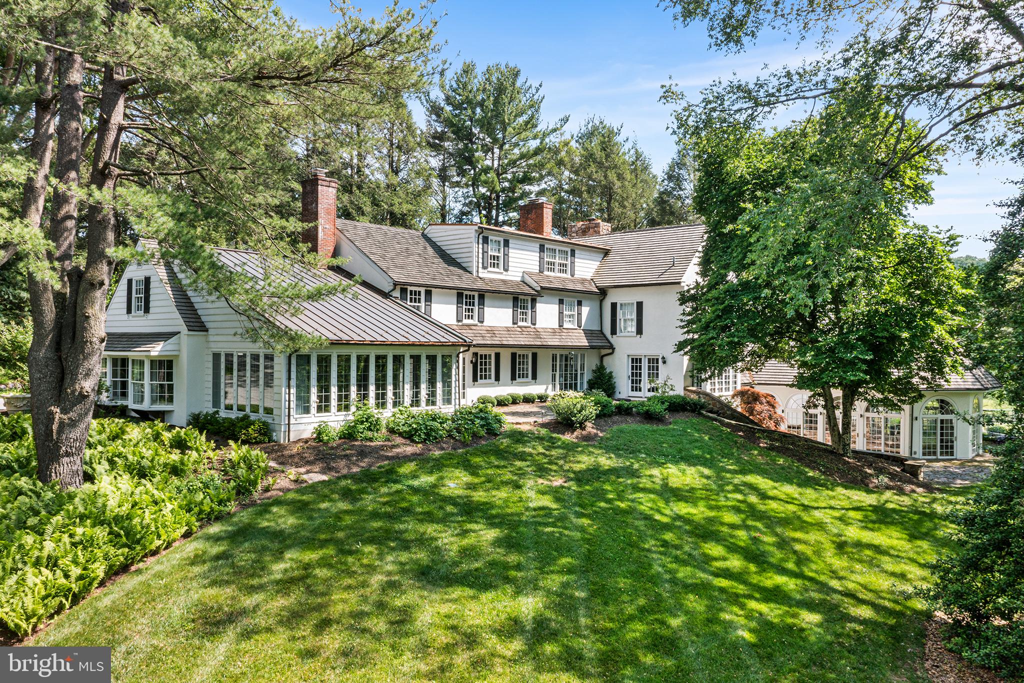 Welcome to 2490 White Horse Road.  "Meadowmist" is a fully renovated, classically and elegantly designed 4 bedroom traditional style home sited on the highest elevation of six picture-perfect acres on one of Easttown Township's most coveted winding country roads.  Privacy abounds as the house is approached up a long driveway to the back of the lot. "Meadowmist" truly combines luxurious living with breathtaking scenery. Additional supporting structures include a 3 car detached garage with upstairs heated and air conditioned living space and a full bath, a small 2 stall stable, a garden shed and a fenced tennis / basketball / sport court.  A discreetly placed indoor swimming pool with attached spa room rounds out the resort feel of Meadowmist. No detail was overlooked in the home’s recent transformations, from high-end finishes and designer touches to upgraded "smart" features. Enter through a covered stoop into a sweeping two-story formal entrance. One will immediately feel the comforts of home by gleaming hardwood floors, custom millwork, neutral paint, abundant windows with luxurious treatments, designer light fixtures, a state-of-the-art Lutron® lighting system and three fireplaces. The sunlit dining room features a wood burning fireplace, bespoke glass cabinetry and beautiful countryside views. The chef's kitchen boasts a large center island, white inset cabinetry with marble countertops, Subzero® and Thermador® appliances and a walk-in pantry.  The inviting large family room's custom built-ins will delight, providing a casual yet elegant family and friends gathering space with gas fireplace.  Direct access to a panoramic sunroom-dining space with heated synthetic slate floors, coffered-beadboard ceiling and expansive views of the rolling acreage.  A gracious
living room, also with gas fireplace and a private office with custom built-ins, expanded laundry suite, and half bath complete the first floor. Upstairs, the primary suite includes every upgrade and amenity imaginable, from a separate sitting room with window seat and custom built-ins to designer his and hers walk-in closets. The spa-like ensuite bath features a soaking tub beneath a tall arched window, dual vanities, water closet, heated floors and oversized shower with bench.  The second bedroom has a large sitting room/office space with built-ins and hall bath and the third bedroom has a renovated ensuite bath.  The third floor houses the expansive fourth bedroom suite with lounge and renovated bath, and extra storage. The lower level is a wellness haven anchored by a freshly painted, windowed pool house with beamed ceiling and
stone accents, lap lane, hot tub, new sauna and a meditation room with oversized full bathroom with steam shower.  An adjacent kitchenette and lower-level finished rec room add convenience and versatility.  There is an auto lock keypad for both entrances to pool / spa area providing extra security & peace of mind. Outside, enjoy a multi-tiered stone terrace, discreetly sited tennis and basketball/sport court and secondary hot tub. The entire second floor above the detached three-car garage with a full bath and
kitchenette is the perfect in-law suite, 5th bedroom  or home office. Located in top-rated T/E School District and is just minutes from all the Main Line has to offer including Amtrak (Paoli) and Local R5 train service. Continue along White Horse Road to the 90 Acre Kirkwood Preserve for a truly Country experience with mowed walking trails.  This majestic estate exudes luxury and natural beauty at every turn in a fabulous location.