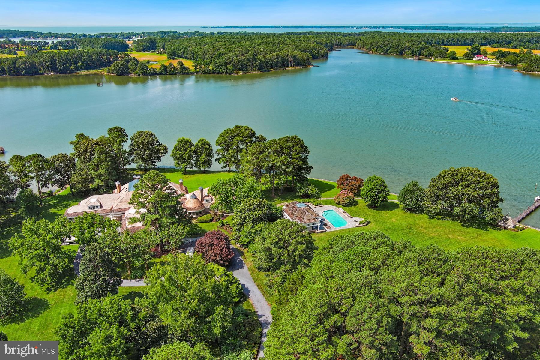Welcome to this extraordinary waterfront estate, gracefully sited on 6.92  lush, landscaped acres with sweeping views of Leadenham Creek. Designed by architect Alan Meyers, constructed by Ilex Construction, and masterfully styled by interior designer Skip Sroka, this 10,000+/-sq. ft. residence is a showcase of timeless craftsmanship and elevated design.

The custom brick exterior is crowned by a new cedar shake roof with copper caps and bands, creating a refined profile that blends seamlessly into the natural surroundings. Double mahogany doors with full-view, artistically designed leaded glass open to a luminous foyer with immediate, breathtaking views of the water.

Inside, riff-sawn red oak floors flow through expansive formal and informal living areas. Vaulted ceilings add architectural drama, while curated lighting provides warmth and sophistication throughout. The main level features formal living and dining rooms, a stunning gourmet kitchen, and multiple spaces designed for both relaxation and entertaining.

The kitchen is a chef’s dream—equipped with top-tier appliances, a large center island,  sitting area with fireplace, and an eat-in dining space. Just off the kitchen, a beautifully crafted screened porch with an octagonal ceiling offers a peaceful, year-round retreat. A walk-in pantry and custom-designed bar enhance both function and hospitality.

Also on the main level is a striking private office wrapped in Anigre wood paneling, featuring custom built-ins and a circular backlit ceiling. A separate guest wing includes a spacious family/recreation room with spectacular river views and two guest suites with ensuite baths.

The primary suite enjoys its own private wing, with serene water views, a cozy sitting area and fireplace, dual  walk-in closets, and an elegant dressing hall. The luxurious, spa-inspired bath includes a soaking tub and glass-enclosed shower, creating a true sanctuary of comfort and privacy.

Upstairs, dual wings on opposite sides of the home offer two additional guest suites with ensuite baths, a bonus/music room, and a dedicated fitness room. Five fireplaces handcrafted by Collecio Brothers Stone Masons bring warmth and timeless character throughout the home.

Modern systems include geothermal heating and cooling, a new Honeywell HVAC control system, Vantage lighting automation, a fully encapsulated crawlspace, and a Generac generator. In addition to the oversized 3+ car attached garage, a separate detached two-bay garage offers equipment storage, a workshop, and a half bath.

Outdoors, the estate is designed for both grand entertaining and quiet waterfront living. Features include an extended waterside patio, beautiful pool house with a  fully equipped outdoor kitchen, two dressing rooms, an outdoor shower, and an in-ground pool with heated spa. Over 1,000 feet of riprapped shoreline and a 210-foot private dock with two slips, a floating dock, and 7-foot MLW offer direct access to the Chesapeake Bay.

This remarkable estate was built for luxurious living, effortless entertaining, and a deep connection to the natural beauty of Maryland’s Eastern Shore.

*Current taxes are based on homestead credit.
