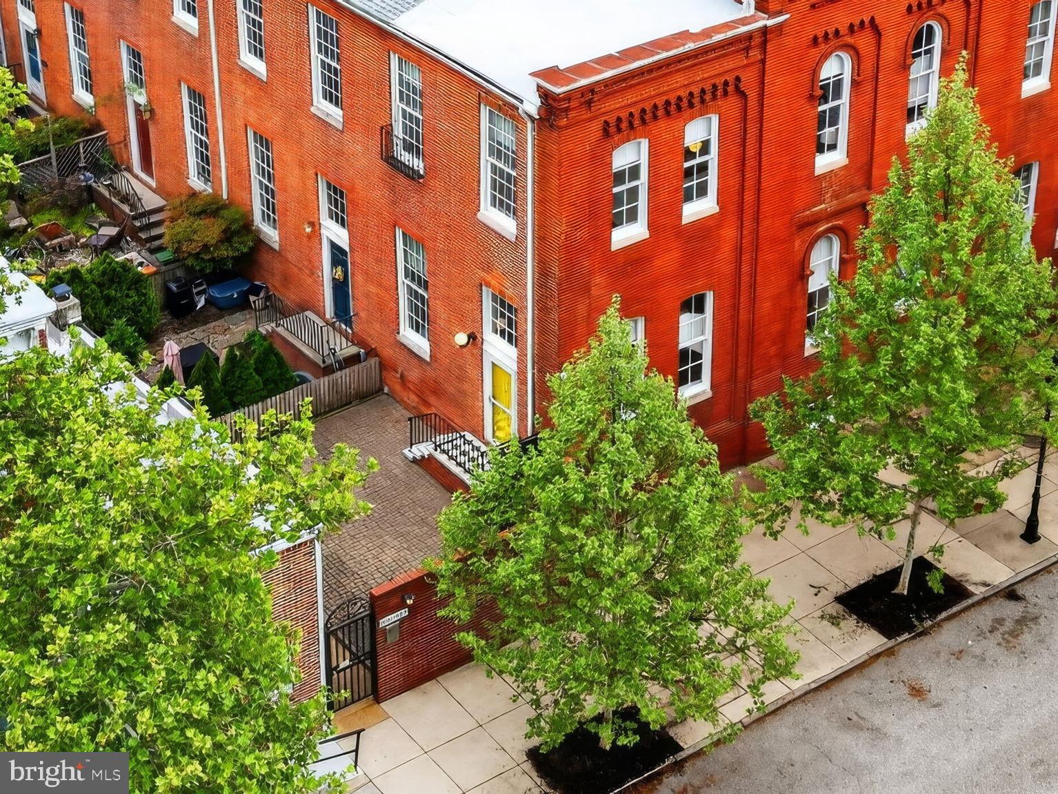 OFFER DEADLINE: Seller is requesting all offers be submitted by Sunday, May 3rd at 5pm. Own a piece of Baltimore history with this stunningly reimagined 1869 Schoolhouse corner unit.  Blending rich architectural character with exceptional modern luxury, this standout piece of Baltimore real estate offers an unmatched urban lifestyle. This home perfectly balances historic charm with a fast-paced, highly connected city life. Step through the welcoming foyer and immediately notice the soaring 12-foot ceilings and original hardwood floors that flow seamlessly throughout the first and second levels. The expansive, sunlit living area centers around a cozy wood-burning fireplace, transitioning smoothly into a dedicated dining space. At the heart of the home sits a farmhouse kitchen. You will love preparing meals surrounded by crisp white cabinetry, rich butcher block countertops, stainless steel appliances, including a gas stove, and a classic farmhouse sink. Stairs with a landing take you to a thoughtfully designed second level. At the top of the steps is a professionally designed and organized hall/linen closet, where things can be hung and toiletries stored. Both bedrooms feature their own private, full en suite bathrooms. The primary suite boasts a spacious walk-in closet with white subway tile. A wooden ladder reveals unique bonus storage nestled above the closets and baths of both rooms. Downstairs, the finished basement features durable LVP flooring, offering a versatile bonus space perfect for another bedroom, home office, personal gym, or media room, alongside a large laundry/utility area with a front-loading washer and dryer. This renovated property doesn't just deliver on interiors; the exterior and community perks are extraordinary. Relax and enjoy your private 450 square foot patio. Experience the peace of mind that comes with a gated, secure entrance and your own assigned parking spot on a private lot on a quiet residential street. UNBEATABLE PROPERTY HIGHLIGHTS—Recent Upgrades: New roof (2025). Carrier hybrid HVAC, heat pump and furnace (2024). Sump Pump (2025). Stainless Refrigerator (2025). Stainless Dishwasher (2024). Storm Door (2022). LVP floor in basement (2022). Washing machine (2021). Exclusive Perks: Skip the five-year waitlist—a highly coveted Otterbein Swim Club membership is conveyed directly to the new owners. Tennis courts and a playground sit steps away. This historic home boasts a prime location that simply cannot be matched. Take a quick five-minute walk to M&T Bank Stadium, Camden Yards, and the vibrant nightlife and award-winning dining of Federal Hill. Commuting is effortless with the MARC train and Light Rail practically in your backyard, plus immediate access to I-95 and 295. Opportunities to secure a spectacular, move-in-ready corner unit in this neighborhood are incredibly rare. Ready to see it for yourself? Contact us today to schedule your private tour!