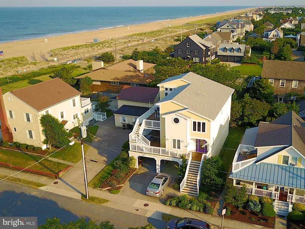 Enjoy excellent ocean views, sunrises, and gentle ocean breezes from almost every angle of this stunning South Rehoboth home. Situated just steps from one of Rehoboth’s most desired beaches and boardwalk, properties in this location are rarely available. This coastal home features 5 bedrooms, 4.5 tastefully updated baths, an inverted floor plan providing stunning ocean views, an abundance of natural light, and open concept perfect for entertaining. The spacious living area includes a gas fireplace, gourmet kitchen, formal dining room, hardwood floors, executive office which could be the 5th bedroom and much more. Exterior features include generous deck space, full bathroom accessed from exterior, large storage room for bikes and beach toys, backyard space, loads covered parking (6+ cars) and more!  This home has been enjoyed as a second home but offers excellent rental potential!
