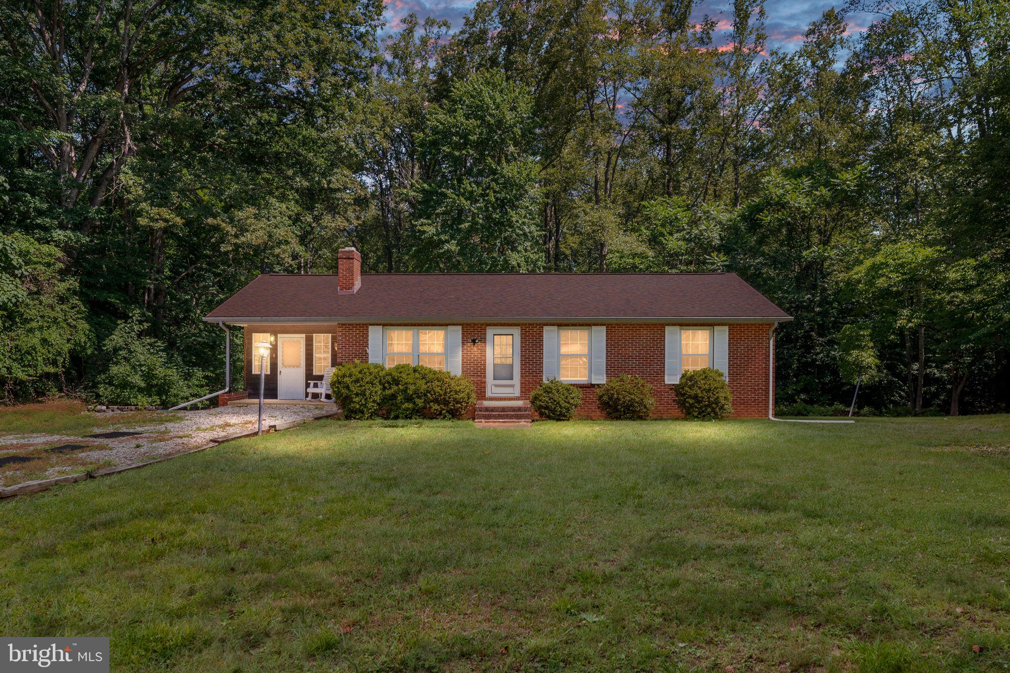 Privately situated at the end of a driveway and surrounded by mature trees, this all-brick rambler offers a rare opportunity to create something truly special. Set on a spacious 3.10 acre lot with generous front, side, and rear yards, this property provides the peaceful setting you've been searching for while remaining just minutes from Quantico Marine Corps Base, government facilities and contractors, I-95 Express Lanes, Route 1, commuter lots, shopping, dining, recreation, places of worship, and highly regarded Stafford County schools.  Inside, you'll find a traditional floor plan featuring 3 bedrooms, 1.5 bathrooms, natural hardwood flooring in the living room, and a flexible enclosed carport that adds valuable living space ideal for a home office, craft studio, fitness area, or whatever suits your needs.  The spacious walk-out basement offers tremendous potential with multiple finished rooms and a half bath already plumbed for future expansion to a full bathroom. Whether you're envisioning additional living space, a workshop, hobby areas, or storage, the possibilities are extensive.  Step outside onto the deck overlooking the peaceful backyard and enjoy the beauty of the mature trees and natural surroundings. Multiple storage sheds provide ample room for tools, equipment, and outdoor projects.  This home is ready for its next chapter and presents an excellent opportunity for buyers seeking to renovate, personalize, and build equity. Bring your vision, creativity, and remodeling ideas to transform this solid brick home into a showcase property in an exceptionally convenient Stafford County location.