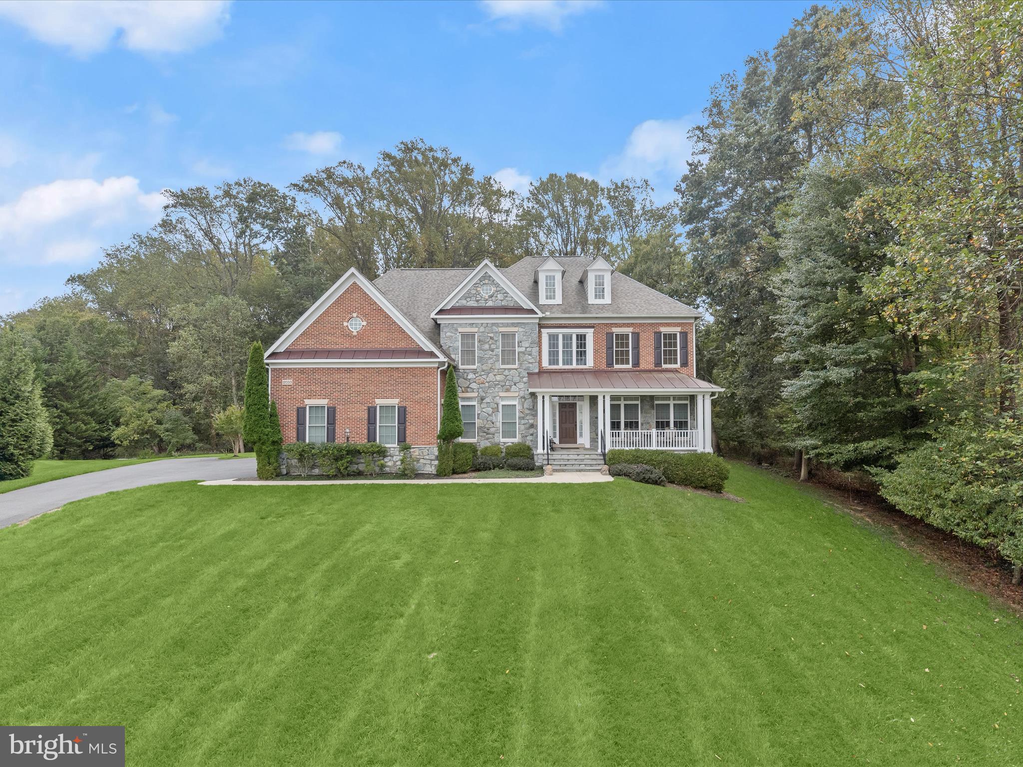 IMMACULATE!  
Welcome to this stunning, LIKE-NEW Winchester Belmont model in the sought-after Riverwood community. Built in 2011 and thoughtfully upgraded to perfection, this 5-bedroom, 4.5-bath home sits on a beautiful1.22-acre lot with Howard County preservation land on the side and rear, and common area in front, creating a very private and open feel.
Step onto an expansive front porch and enter a grand two-story foyer with a curved staircase with a plush runner, walnut floors, and rich architectural moldings. The main level boasts living and dining formals with added length for a piano, a private study, and a spacious family room with a wall of stacked windows and a gas fireplace. The gourmet kitchen wraps around a commanding center island with a breakfast bar, and is equipped with a walk-in pantry, granite surfaces, and stainless appliances. The adjacent breakfast area is sided by a planning desk and secondary back stair on one side and an atrium door on the other side that opens to the Trex deck with a plumbed gas hook-up—perfect for outdoor entertaining. Plush upgraded carpeting, and a 4’ bump-out add space, comfort and function throughout.
Upstairs, the primary suite features a generous layout with a tray ceiling and two-sided fireplace that is shared by the bedroom and sitting room.  Oversized walk-in closets flank the entrance to a dramatic spa-inspired primary bath featuring a soaking tub, two separate vanities, a walk-in shower and a generous linen closet.  Three additional ensuite bedrooms provide ample accommodations. A convenient upper-level laundry completes the floor. 
Downstairs, a fully finished lower level includes a fifth bedroom, and full bath.  Full daylight streams into the recreation room through an atrium door and double walk-up stair to the rear lawn and outdoor living. Additional rooms are finished with luxury plank floors that include an exercise room, finished storage with substantial shelving and the spacious fifth bedroom.
Exterior highlights include a slate-covered front porch, brick and stone accents, a 3-car side-loading garage prepped for generator or EV charging, and a short walk-up stair. Recent upgrades bring peace of mind: new HVAC (2025), hot water heater (2021), 20-year roof (2021), and gutter system (2021). Additional amenities include a sprinkler system, sump with backup, reverse osmosis water, and radon mitigation system.
All of this is in a prime location close to Centennial Lake, great schools, shopping, dining, and parks. This truly exceptional home has been meticulously maintained and shows like a model.  Offering a rare opportunity combining luxury, function, and location with a home in pristine condition.  This home is move in ready and simply better than new!