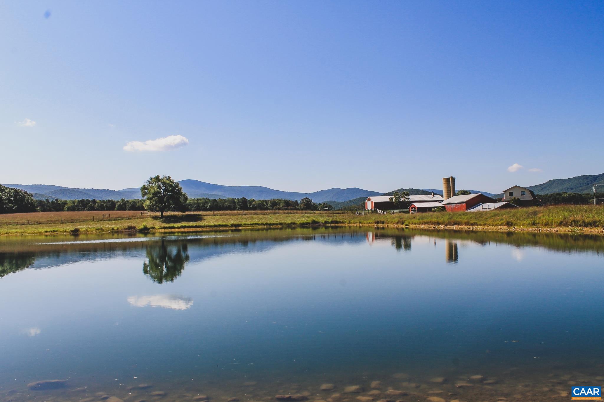 REDUCED! This is an amazing opportunity to own a large farm and home based at the foothills of the Shenandoah National Park. These 136 acres come with spectacular, panoramic Blue Ridge Mountain views, 2 stocked ponds with one that is nearly 5 acres, 3 storage barns, and a 5 bedroom home. The entirety of the property is fenced as it is currently used for grazing cattle. However, it would make an exceptional equestrian property as one or more of the 50'x100? storage barns could be converted to stables or an indoor riding ring. There are already 2 MiraFlow waterers in the pastures for year round water for your animals. The land is mostly open and is flat to gently rolling, with a few acres of beautiful white oak trees stretching to the waters edge of the 5 acre pond. The 3 story home is just over 4,000 sq ft, including a walkout basement and attached 2 car garage. This property is located just minutes from a Shenandoah National Skyline Drive entrance, 15 minutes from Massanutten Resort and Waterpark, and 25 minutes from Harrisonburg.,Wood Cabinets,Fireplace in Basement,Fireplace in Living Room