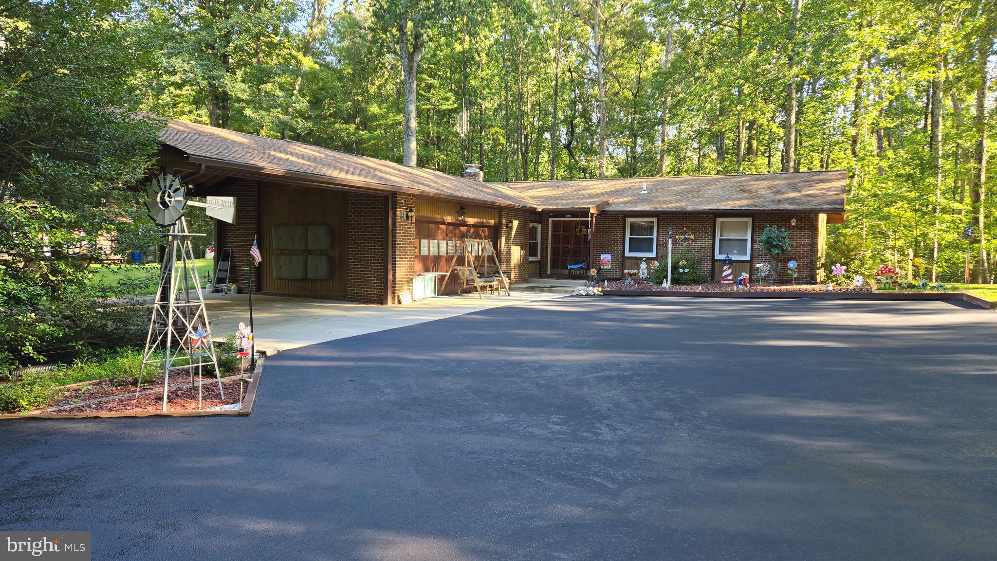 HOUSE IN THE WOODS ON 1 ACRE (OPEN, FLAT, TREED).  IDYLLIC! NO HOA!  2 CAR GARAGE, 2 CAR CARPORT.  SPACIOUS ASPHALT PARKING.  DOUBLE WOOD DOOR ENTRY.  3 BEDROOMS, 2 FULL BATH  REMODELED (2024) QUARTZ KITCHEN.  UPDATED KITCHEN APPLIANCES (2024).  SPACIOUS DINING AND LIVING ROOM.  COZY FAMILY W/ BRICK FIREPLACE.  NEW PRESSURE TANK (2026) FOR WELL,  ALL-IN-ONE FULL-SIZED WASHER/ DRYER (2025), LVT FLOORING (2025), SPLIT RAIL FENCE (2025),  KITCHEN APPLIANCES (2024), HOT WATER HEATER (2023), ROOF (2017), WINDOWS (2012).  WASHER/ DRYER GE PROFILE --WORKS ON 110 PLUG IN!  NOTE:  KITCHEN IS WIRED FOR DISHWASHER (REMOVED FOR NON-USE).  CABLE AVAILABLE.  DIGITIAL ANTENNA INSTALLED HAS 51 CHANNELS.  2ND SEPARATE ENTRANCE DRIVEWAY TO BACKYARD TO HAND BUILT WOOD SHED (12X20) USING BEST MATERIALS  AND  AN OPEN SHED ON A SLAB W/ ROOF (12X20).