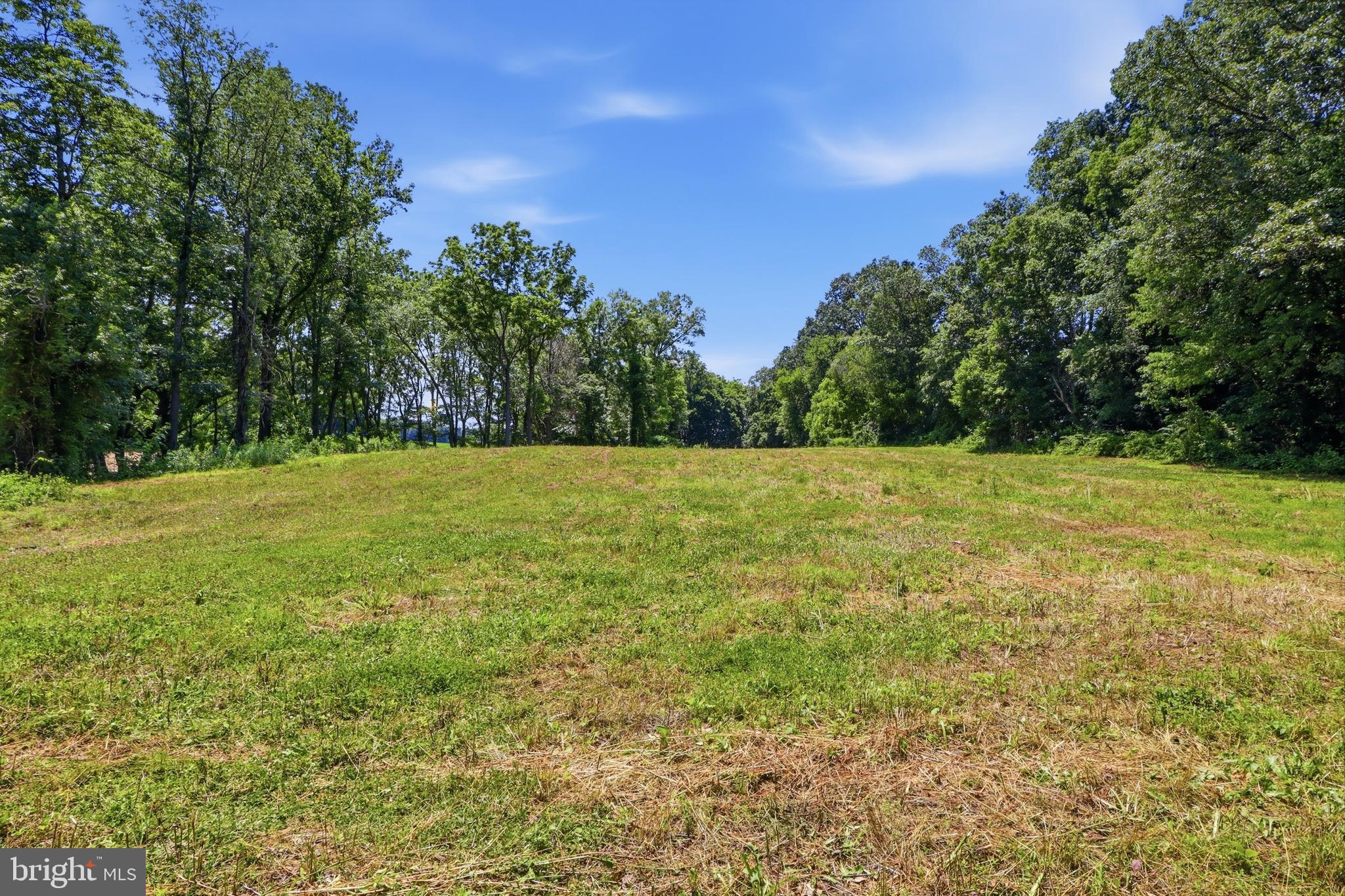 Discover the rare opportunity to create your dream home on nearly seven picturesque acres in the heart of northern Harford County. Nestled along a peaceful country road in White Hall, this exceptional property offers the perfect balance of privacy, natural beauty, and convenience.

The property features a stunning elevated homesite overlooking a diverse landscape of open fields, mature woodlands, and the gently flowing Island Branch stream. A forested buffer along the stream creates a natural sanctuary that attracts abundant wildlife and provides a serene backdrop for everyday living. Surrounded primarily by preserved farmland and protected natural resource lands, the property offers breathtaking rural views that will remain intact for generations.

Whether you envision a custom estate home, a charming farmette, an equestrian retreat, or a hobby farm, this versatile property provides endless possibilities. The acreage offers ample space for horses, livestock, gardens, greenhouses, orchards, recreational trails, hunting, or agricultural pursuits. Entrepreneurs may also appreciate the potential for certain construction service business uses, subject to applicable approvals.

One of the property's most attractive features is the freedom it provides. There are no private covenants, restrictions, or homeowners' association requirements, allowing you greater flexibility to design, build, and enjoy your property in a manner that reflects your vision and lifestyle.

Located just minutes from Norrisville, residents enjoy access to the highly regarded Norrisville Elementary School, the local recreation center, playgrounds, library, and the close-knit sense of community that makes this area so desirable. The surrounding countryside is known for its scenic beauty, family-owned farms, orchards, seasonal festivals, farm markets, breweries, parks, and outdoor recreation opportunities.

Despite its tranquil rural setting, the property offers convenient access to Hunt Valley, Bel Air, Towson, and York, making commuting and everyday shopping easily accessible while allowing you to return home to the peace and quiet of country living.

The property is ready for your vision, featuring a new high yielding well and approved perc testing for a future septic system. With tillable farmland, mature woodland, a stream, and a premium homesite already in place, this remarkable property presents a unique opportunity to build a legacy property where family traditions and lasting memories can be created for years to come.