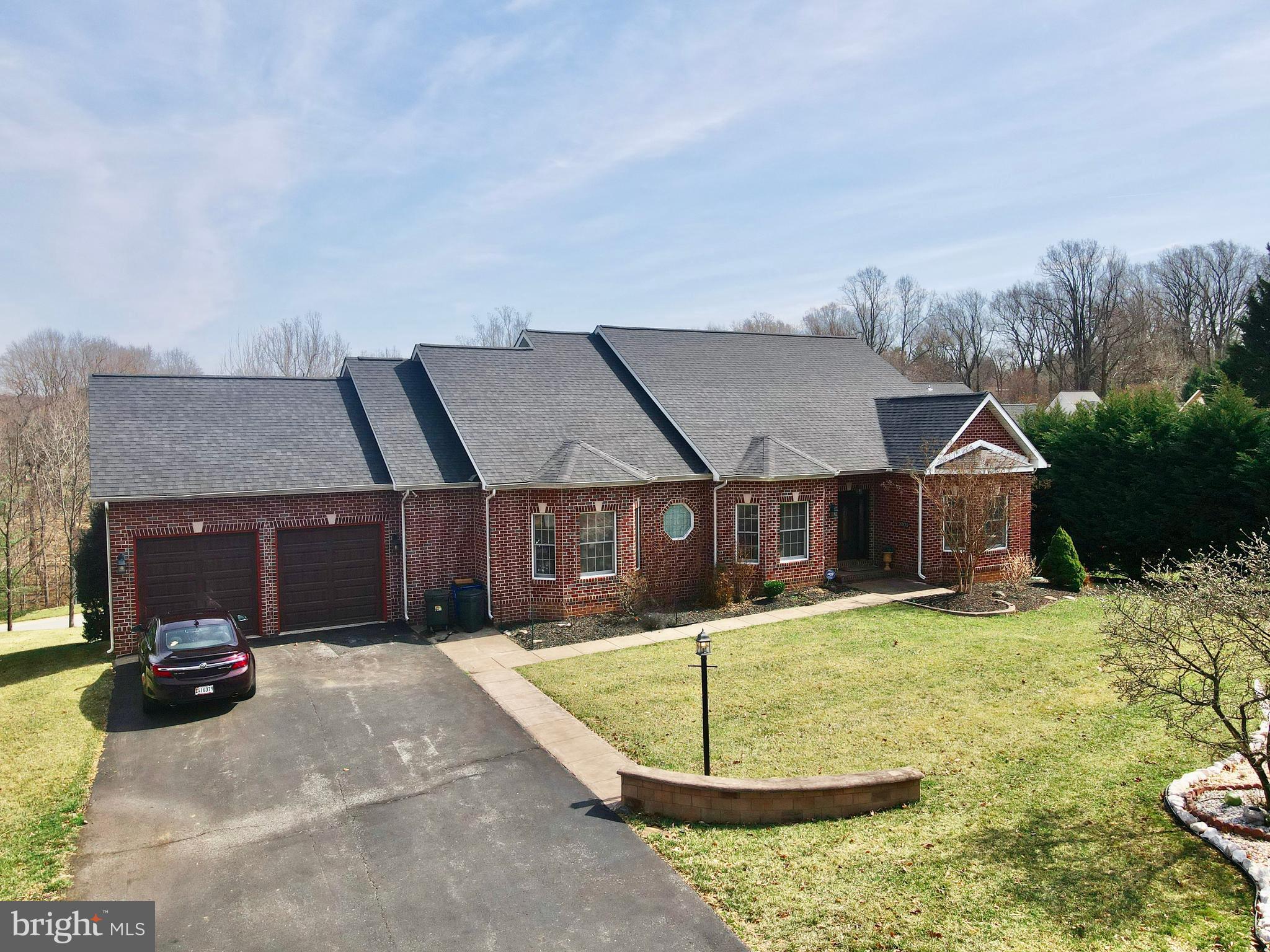 Nestled on a private cul-de-sac in one of Ellicott City's most desirable neighborhoods, this elegant brick-front rancher offers an exquisite blend of timeless charm and modern comfort. Boasting over 4,000 square feet of thoughtfully designed living space, this home welcomes you with an open-concept layout, seamlessly connecting the living room, family room, and formal dining area. The chef’s kitchen is a culinary delight, featuring a built-in countertop range, double wall oven, dishwasher, and refrigerator—perfect for both everyday living and entertaining. The private primary suite is a true retreat, offering direct walk-out access to the expansive rear deck, dual walk-in closets, and a spa-like bath complete with a soaking tub, walk-in shower, and double vanity. Two additional generously sized bedrooms, a full bath, and a powder room complete the main level. A conveniently located mudroom with laundry connects directly to the oversized two-car garage for effortless functionality. The lower level extends the living space with a versatile layout, featuring a spacious bedroom, a potential second bedroom or home office with custom built-ins, a full bath, and an entertainment area with a built-in bar—ideal for hosting gatherings. Ample storage is provided by multiple storage rooms with built-in shelving. Step outside to the large rear deck, perfect for enjoying morning coffee or evening relaxation. Situated on a quiet cul-de-sac, this home offers privacy and tranquility while being just moments from Routes 29 and 70 for easy commuting. Don’t miss the opportunity to own this stunning residence in an exceptional location! Recent updates: Roof 2022, Hot water heater 2023, Garage doors 2024