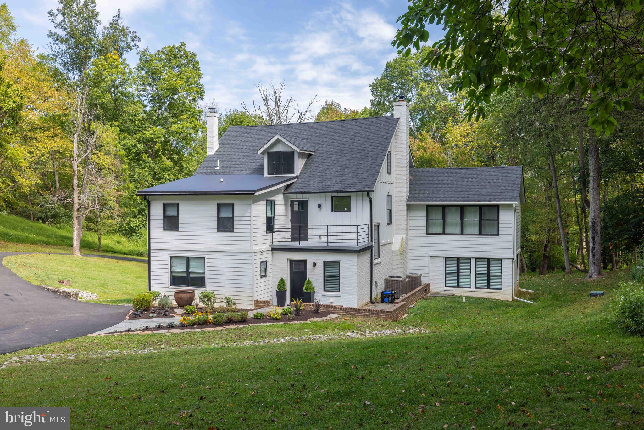 Set amidst a serene and picturesque landscape, this remarkable 7.23-acre Greenville estate seamlessly blends historic charm with modern luxury. Spanning two separate parcels—one with the main residence on 5.09 acres and the other with a carriage house on 2.13 acres this property offers flexibility, privacy, and endless possibilities. Fully renovated in 2020, both residences capture breathtaking views from every window. Whether envisioned as multi-generational accommodations, a guest retreat, or a private sanctuary, this estate is designed to adapt to your lifestyle. The main residence features five bedrooms and three-and-a-half baths within a spacious, inviting layout. Step into the grand open foyer and choose your path—toward the expansive kitchen and family room, or into the mudroom and gathering area. The open-concept design of the kitchen and family room creates a natural space for entertaining, while a private den, movie room, or study offers quiet reprieve. Outside, the covered patio provides the perfect spot to relax with a glass of wine while enjoying the tranquil setting, where deer, foxes, and other wildlife make frequent appearances. Upstairs, two spacious bedrooms, a hall bath, and a convenient second-floor laundry accompany the owner’s suite. This private retreat offers a spa-like bathroom, an expansive walk-in closet, and sunlit sleeping quarters framed by panoramic windows. An upper porch extends the living space outdoors with views across the property at the rear and a recently rebuilt private balcony at the front of the home offers a charming place to relax and enjoy nature. The third floor provides two additional bedrooms and a private bath, ideal for large families or hosting guests. Automotive enthusiasts will appreciate the abundance of garage space, including three detached single garages with two heated bays, a brand-new oversized 30' x 30' detached heated garage that houses 4 cars, and an additional work and storage area to accommodate hobbies or extra storage. A new driveway was completed in 2025. The charming carriage house, nestled on 2.13 acres, features three bedrooms and three full baths. A cozy family room with wood stove and a quaint kitchen add character, while beautiful hardwood floors lend timeless warmth. Completely renovated in 2022 with a new septic system and well, this home is move-in ready. A new driveway was added in 2025. Backing directly to Bidermann Golf Course, the carriage house offers sweeping views and a serene setting—an ideal retreat for guests, extended family, or potential rental income. This estate offers a unique combination of luxury, privacy, and versatility, making it truly one of a kind. The two separately deeded parcels include Parcel 07-013.00-004 (5.09 acres) and Parcel 07-013.00-003 (2.13 acres), which backs to Bidermann Golf Course. A driveway easement provides access to the rear property.