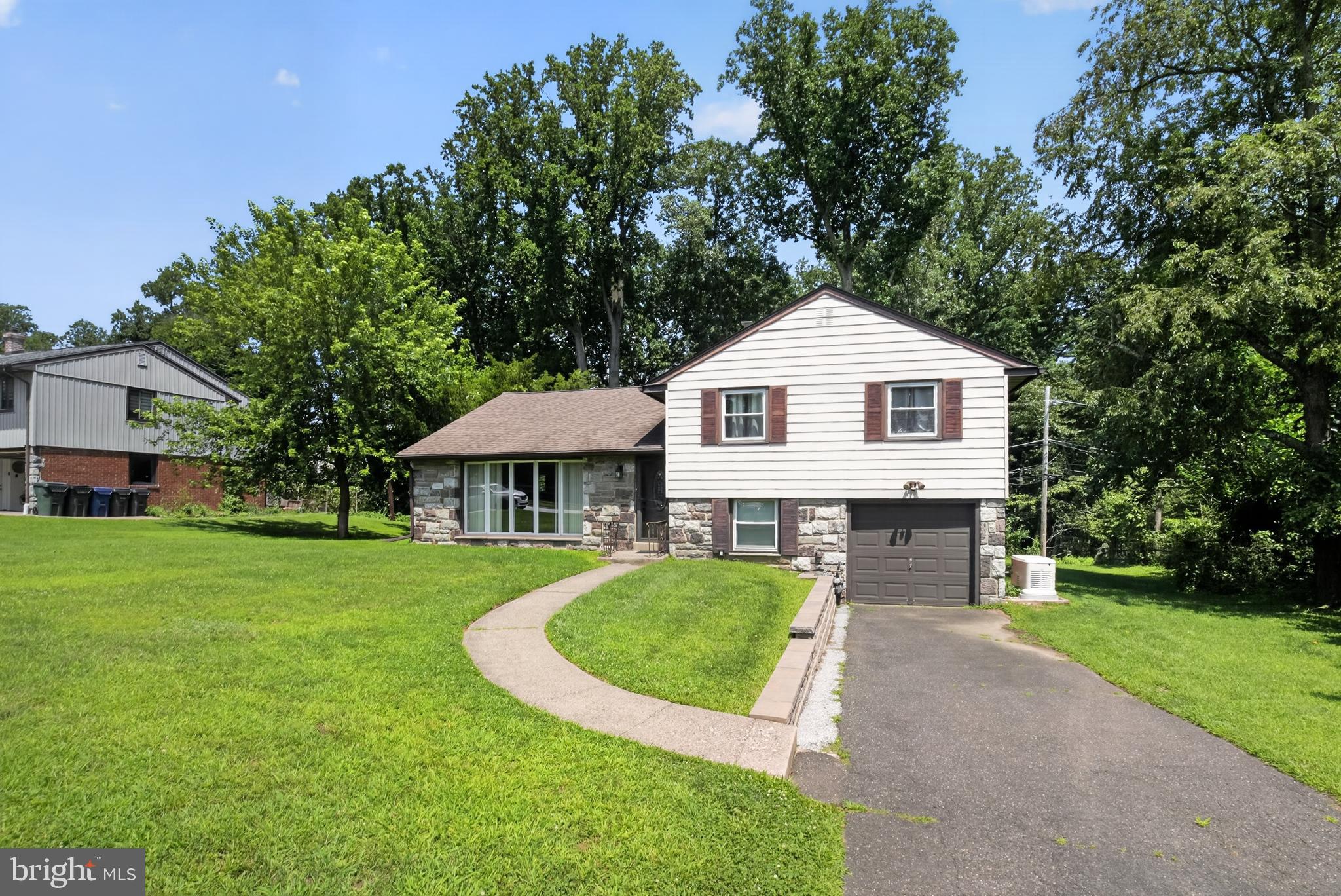 Welcome to this beautifully maintained split-level home offering the perfect blend of comfort and space. 
Step inside to a spacious living room that flows seamlessly into the elegant dining room, creating an inviting layout for everyday living and entertaining. The eat-in kitchen features ample counter space and cabinet space. Upstairs, you’ll find three generously sized bedrooms with spacious closets, a master full bath and a full hall bath.  The lower level offers even more living space with a large family room that’s perfect for entertaining, relaxing, or hosting game nights.  This level also includes a convenient powder room and a utility room for more added storage.  Step outside to the huge backyard, where a spacious concrete patio provides the ideal setting for year-round barbecues, outdoor gatherings, and entertaining family and friends. Additional highlights include a large driveway, an attached one-car garage, and the peace of mind of a whole-house generator to keep your home powered during electrical outages.

Close to parks, shops, schools and transportation. Easy commute to anywhere. This home is yearning for its new owner. MAKE THAT OWNER YOU! Don't let this home slip by! Make your appointment today!!