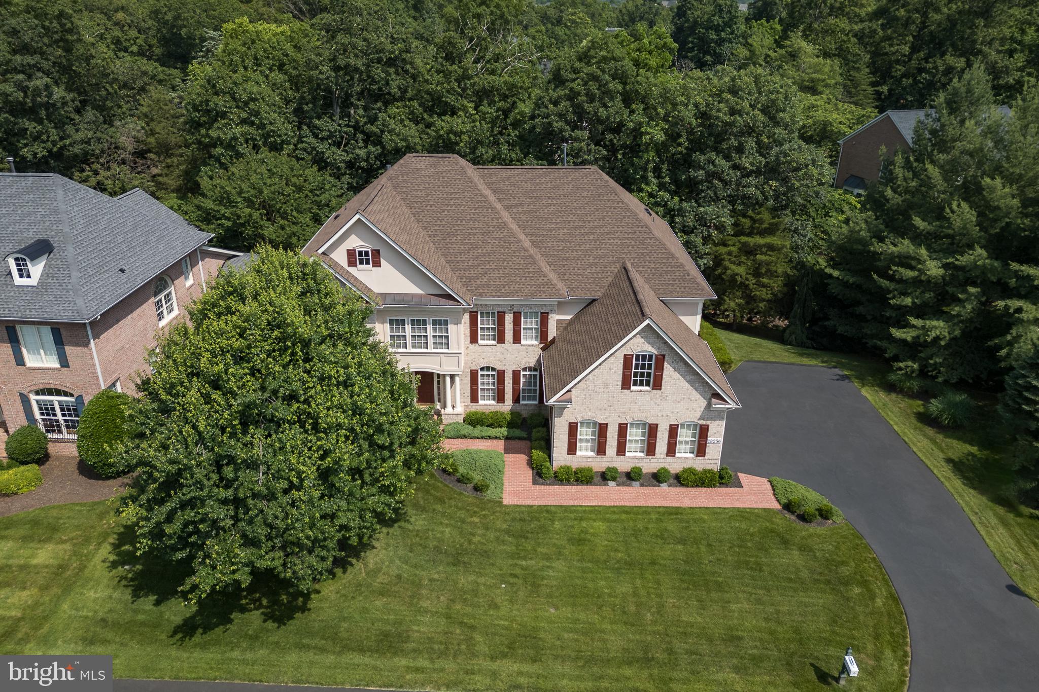 **MASSIVE Price Improvement** Remarkable custom-built home by Mitchell and Best, a custom builder whose motto is “What Vision Can We Bring To Life.” For the first time being offered, this stately, four-sided brick residence is rich with architectural details and accents, offering an impressive first impression. The property boasts a covered entrance and practical upgrades, including a newer extended driveway, newer garage doors, and a pristine garage featuring rubber flooring. Essential updates ensure peace of mind, such as Roof (2020) HVAC's (2019). A decorative covered brick patio, complete with an under-deck drainage system, deck stairs, and privacy lattice, provides exceptional outdoor enjoyment. Enjoy privacy on three sides of the property, with views of the golf course from the front, a natural tree buffer on one side, and mature trees and babbling brook views to the rear. Step inside to discover a beautifully appointed interior. The main level welcomes you with a grand foyer entrance and features such as upgraded trim, wainscoting and hardwood flooring throughout. The family room is enhanced by custom trim details and decorative columns. The formal living room offers flexibility as an optional piano room or untouched office. A versatile office, which can also serve as an optional bedroom, provides access to the deck and custom bookshelves. The inviting family room showcases marble flooring, a stone fireplace, a raised ceiling, decorative columns, recessed lighting, and a curved window wall with transom windows, creating a bright and airy space. The kitchen is a chef’s dream, complete with a butler’s pantry and an eat-in area. It features trim, tall mocha cabinets, recessed lighting, a cooktop with downdraft, a double oven, a SS refrigerator, a custom backsplash, a large island perfect for food preparation with ample space for four stools, a vegetable sink, a window over the sink, a large pantry, and a convenient desk area with a mail holder. Ascending to the upper level, you’ll find the luxurious primary suite, featuring a raised ceiling, cherry hardwood flooring, trim, a double-sided fireplace, and a sitting room that can be converted into an additional bedroom. A wet bar with a sink, beverage refrigerator, backsplash, and tile flooring adds a touch of indulgence. The opulent primary bathroom offers dual water closets, dual showers, garden tub, oversized tile flooring, granite countertops, and cherry cabinets. The dressing area includes full-length mirrors and a window bench, and two walk-in closets. Additionally, there is an en suite bedroom with a walk-in closet and private bath, as well as Jack and Jill bedrooms sharing a bath with one of the bedrooms offering the potential for an amazing office space with a custom window overlooking the grand foyer. The lower level provides fantastic additional living space. A custom bar with upgraded tile, a beverage refrigerator, granite countertops, a sink, a dishwasher, tile flooring, and glass cabinets is perfect for entertaining. The enormous lower-level family room offers distinct billiards and movie areas, enhanced by a double-sided fireplace. An extended sitting area provides additional comfort. Two generously sized bedrooms are also located on this level, along with a walk-out to a private all-brick covered patio. This amazing community offers resort amenities that include: over 7 miles of walking paths, a private park, kayaks, access to dining overlooking the Potomac River, multiple tennis/pickleball courts, swimming pools, exercise facility, secure community access and the option to become a member of River Creek Golf Club. Just outside of the community you will experience convenient access to a wide variety of shopping, entertaining options to include: One Loudoun, Town of Leesburg Wegmans, Whole Foods, Loudoun County Metro Stations, local restaurants, wineries, breweries, farm markets, bike trails, and so much more - Welcome to  a Lifetime of Saturdays!
