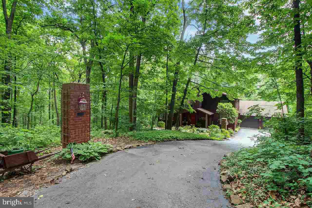 Sitting back off the road in a wooded paradise! This contemporary 2 story home has been remarkably maintained! Featuring Hardwood flooring, Floor to Ceiling Brick FP, Vaulted Ceilings, Kit w/Granite Counters, Ceramic Tile Back Splash, Built in Appliances, 1st floor Lndry, Full W/O Bsmt w/ Family Rm, Wood Stove, Game Rm, Play Rm, 1/2 bath, Utility Rm. Large wrap around deck partially covered, Loft Area, Mstr Suite w/ full bath, & W/I Closet.