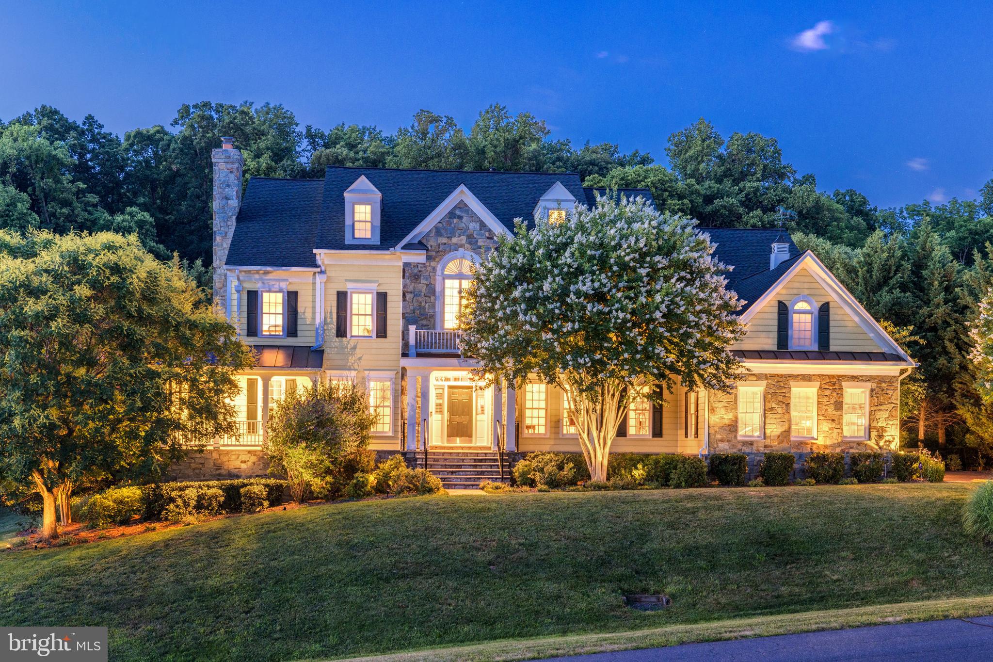 Escape to your own private countryside retreat, where old-world grandeur seamlessly blends with modern luxury in a prime future-golf course location (proposed by Spring of 2025)  The nearly 1 acre of mature gardens and lawns has the feel of 20+ acres of your own property without the maintenance as it backs to preserved community space.   This stunning home offers an unparalleled living experience, complete with an entertainer's pool, all embraced in the tranquil privacy of trees and manicured gardens. Arrive to expansive views of rolling hills and treetops. Timeless architectural appeal, from the upgraded fieldstone exterior to the private wraparound porch, beckons you to relax and explore the idyllic surroundings. Step inside the formal entry, where an elegant foyer adorned with premium Desert Pink marble awaits, a luxurious touch also found in the primary and powder baths. Light-filled living areas include a front living room with a floor-to-ceiling fireplace, a formal dining room with a butler's pantry, and a breathtaking family room featuring two-story ceilings, a fireplace, and Art Deco-inspired windows that altogether create a one-of-a-kind living experience. The kitchen is a chef's dream, incorporating a sunny eat-in dining area, extended island with breakfast bar, and abundant storage with a walk-in pantry. Sliding doors lead to the enchanting backyard, inviting you to unwind on the deck in the private embrace of trees and mature landscaping. Play on the lawn, dotted with seating areas to better indulge in this outdoor oasis, and follow the hardscape path to your glamorous, resort-style pool. Upstairs, upgraded hardwood floors continue through four generously sized bedrooms. Retreat to your palatial primary suite with a private sitting room, custom shutters, and two huge dressing-room style walk-in closets. The spa-quality primary bathroom features a decadent Whirlpool tub, an oversized step-in shower, dual vanities, and brilliant natural light. Two additional bedrooms share a jack-and-jill bath with double sinks and the 4th bedroom features its own private bathroom and walk-in closet. The lower level hosts extensive flexible space, including a multipurpose room perfect for a gym, bar, or media room, and a huge daylight rec room with a walk-out to the yard and rough-ins for future upgrade potential. An additional living area, bedroom, and full bath create a luxurious guest suite, while unfinished storage space provides ample room for your belongings.   Nearly $200K in options and upgrades including new roof in 2019, replace entire pool deck area 2019,  Pella fiberglass windows on upper level and attic 2019,  New furnace & AC units 2024, hot water heater 2019, replaced driveway 2022.   With a battery backup power system, security system, and central vacuum, this home offers unparalleled comfort and convenience. A 3-stall side-load garage and expansive motor-court provide ample parking for you and your guests. As a member of the future golf club, you'll have the unique opportunity to enjoy peaceful early morning walks on the course before the first golfers arrive and take your cart directly to the 5th tee in the late afternoon for a round of golf at your leisure. Enjoy views of the newly redesigned course, with the highly anticipated reopening in 2025 providing a front-row seat to the action on four holes: #4, #5, #6, and #13.  Beautiful views and access to the 5th hole is just steps away, offering a picturesque backdrop for your daily life. With access to a network of walking trails, including one that meanders along the tree line behind the property, you'll have a serene escape into nature right in your own backyard.  The owners have enjoyed visits from over 100 bird species!  Don't miss this rare opportunity to have all the conveniences of sought after downtown Leesburg and easy access to Dulles Airport while making this your own countryside retreat where luxury living seamlessly blends with the tranquility of nature.