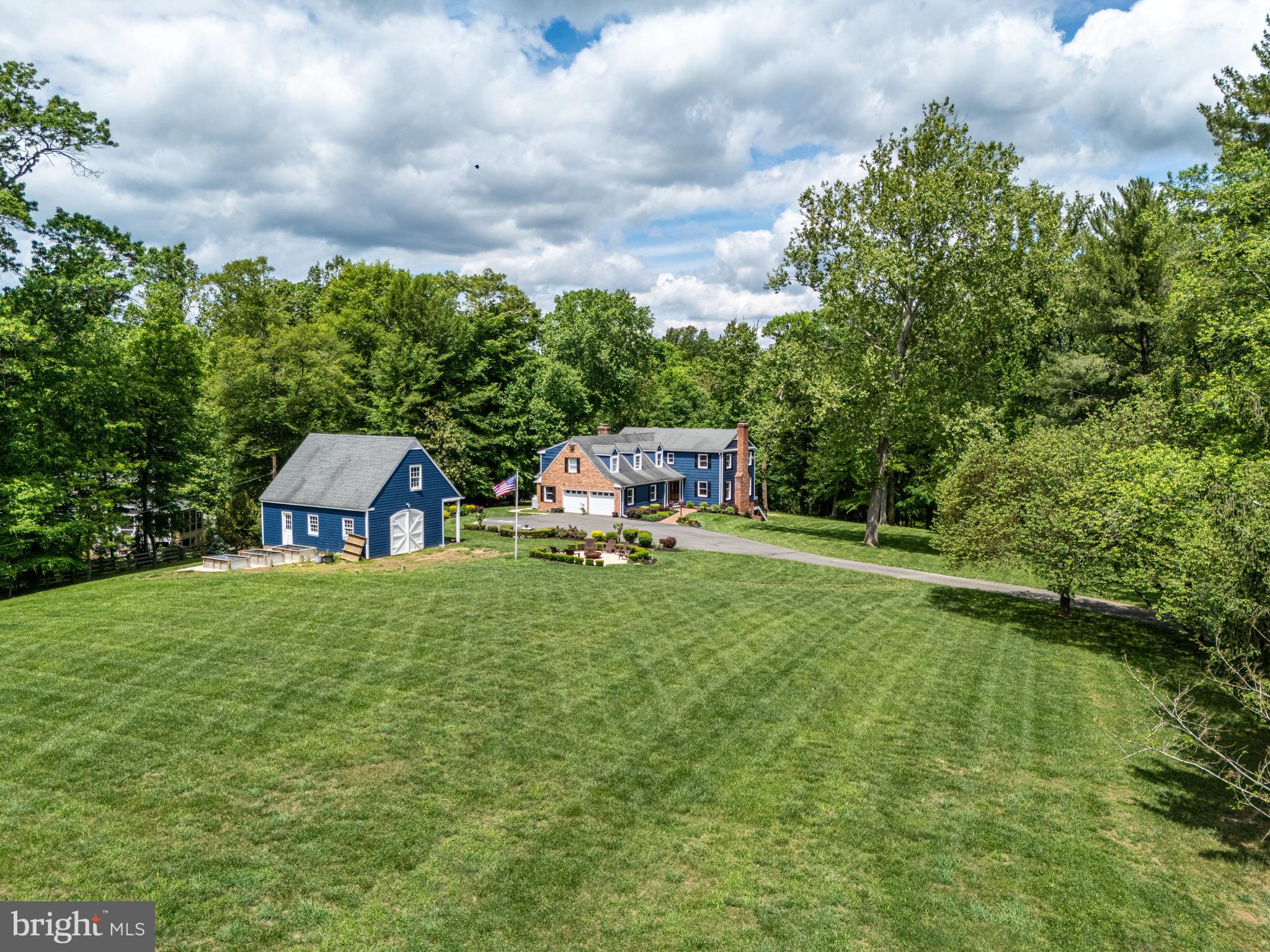 Sited on over five bucolic acres, this country escape is alluring with B&B worthy charisma, modern amenities, and the simple charm of a New England farmhouse. Offering 5 bedrooms, 4 ½ baths and 4600 sq ft of living space, this home blends generous proportions with timeless design. With partially cleared grounds revealing perennial gardens and a barn, this picturesque property provides a peaceful retreat throughout the changing seasons.  Built in 1968 but totally refurbished, you will arrive to find a charming entry enhanced by a clapboard façade.  Inside, both levels are finished with newly installed, tasteful engineered hardwood floors leading to casual and formal living spaces, many warmed by wood-burning fireplaces.  You will enjoy the oversized quartz island in your renovated gourmet kitchen; the high-end appliances are the perfect components for a chef’s kitchen.  Serve holiday dinners in the formal dining room and unwind on the screened porch.  On the upper level you will enjoy four bedrooms and three remodeled bathrooms.  The primary suite allows you to rejuvenate in the cozy sitting room with built-ins and fireplace. The lower level provides a variety of spaces for recreation, an additional bedroom, and office space.  Be sure to visit the charming barn.  This semi-rural gem is down a country lane, but just a few minutes from Riverbend Country Club and Great Falls village center.