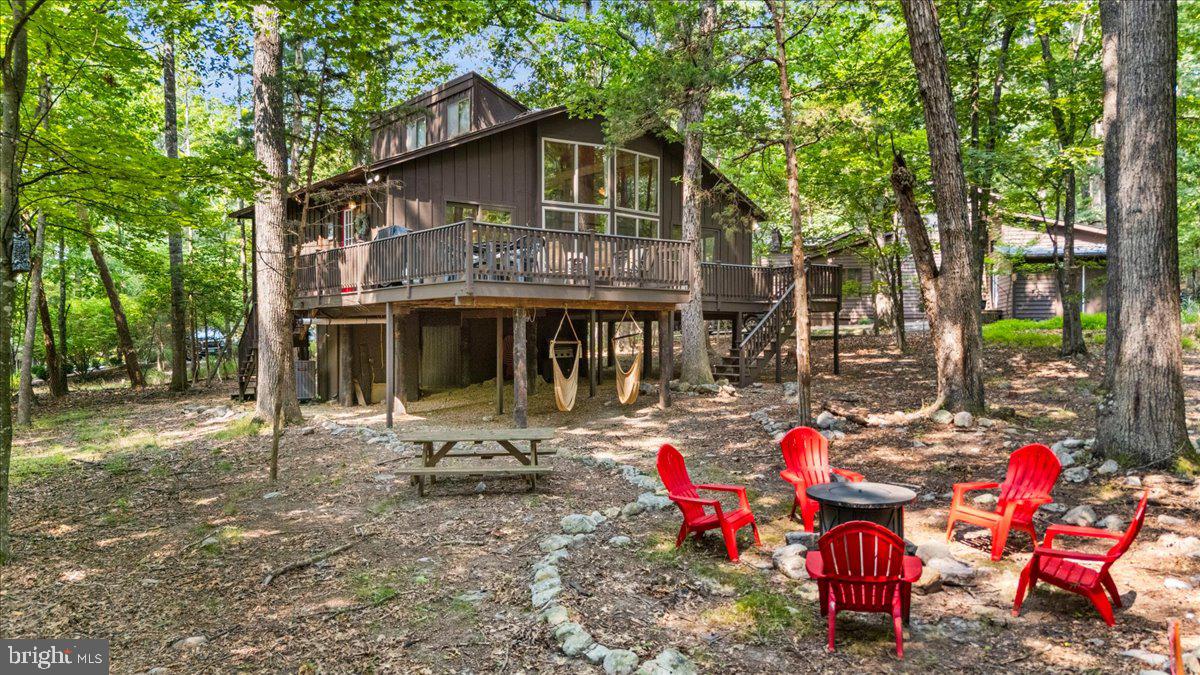 Chalet perched in the woods on a private cul de sac. Vaulted ceilings, floor to ceiling windows (replaced 2023) in living & dining area overlooking the large deck with expansive forest views. Large loft gives additional living & sleeping space. Two new baths (2019 & 2025), new vinyl plank flooring throughout (2019), new gas stove in living room (2019), new heat pump (2023), deck stained in 2026, new tank-less gas hot water heater (2019). Turnkey rental with established rental history being sold completely furnished. Located in the Massanutten community, a four-season resort with skiing, golf, hiking, mountain biking, indoor/outdoor water park, dining and many other amenities.