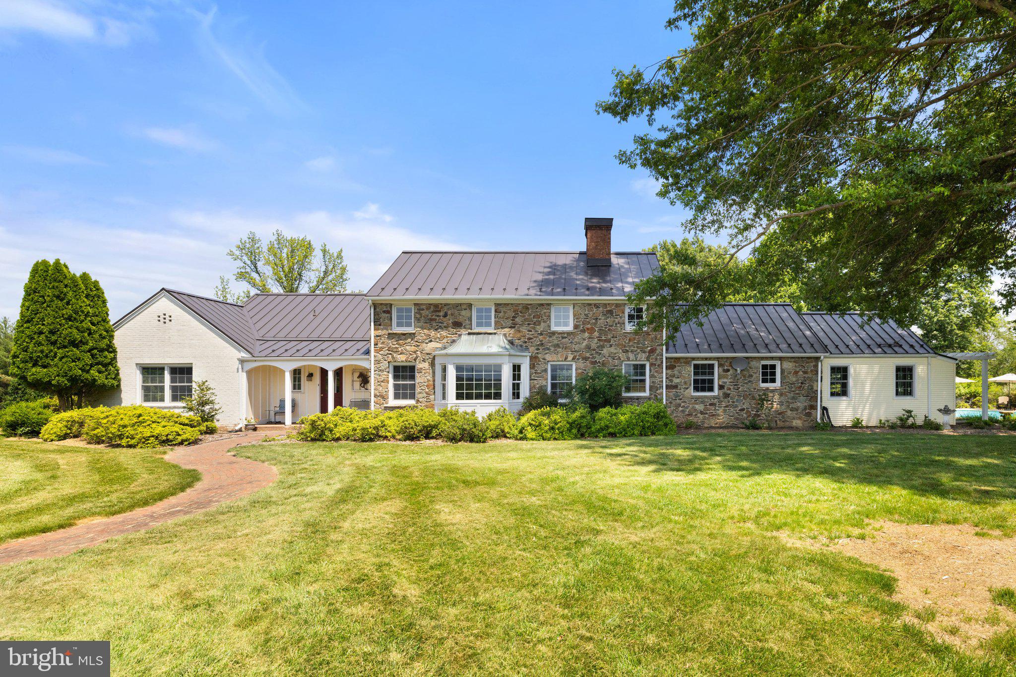 Charming Country Retreat with Mountain Views Near the Village of Philomont

Welcome to this beautifully maintained property on ten private acres just outside the Village of Philomont, offering peaceful western views of the Blue Ridge Mountains. The residence features a main-level primary suite and a thoughtfully updated kitchen with granite countertops that opens to a formal dining room. Both the cozy living room and the den include fireplaces and built-in bookcases, adding warmth, character, and functionality. An additional main-level room serves well as a home office, art studio, or fourth bedroom. A spacious laundry and mudroom are conveniently located just off the kitchen.

Upstairs, two comfortable bedrooms share a full bath.

The exterior invites relaxation and recreation, with mature landscaping, a private in-ground pool, and two patios—one covered and one open—perfect for outdoor entertaining. The property is fully fenced for horses or livestock. Equestrian amenities include a three-stall stable with an additional wash stall, and multiple paddocks. The property also has a detached two-car garage.

The home's exterior features a classic combination of stone, brick, and vinyl siding for timeless appeal and low-maintenance living. A private well yields 25 gallons per minute and is 260 feet deep.
This property offers an ideal blend of comfort, natural beauty, and the enduring charm of Virginia countryside living.

Professional photos will be posted on Tuesday, June 24.