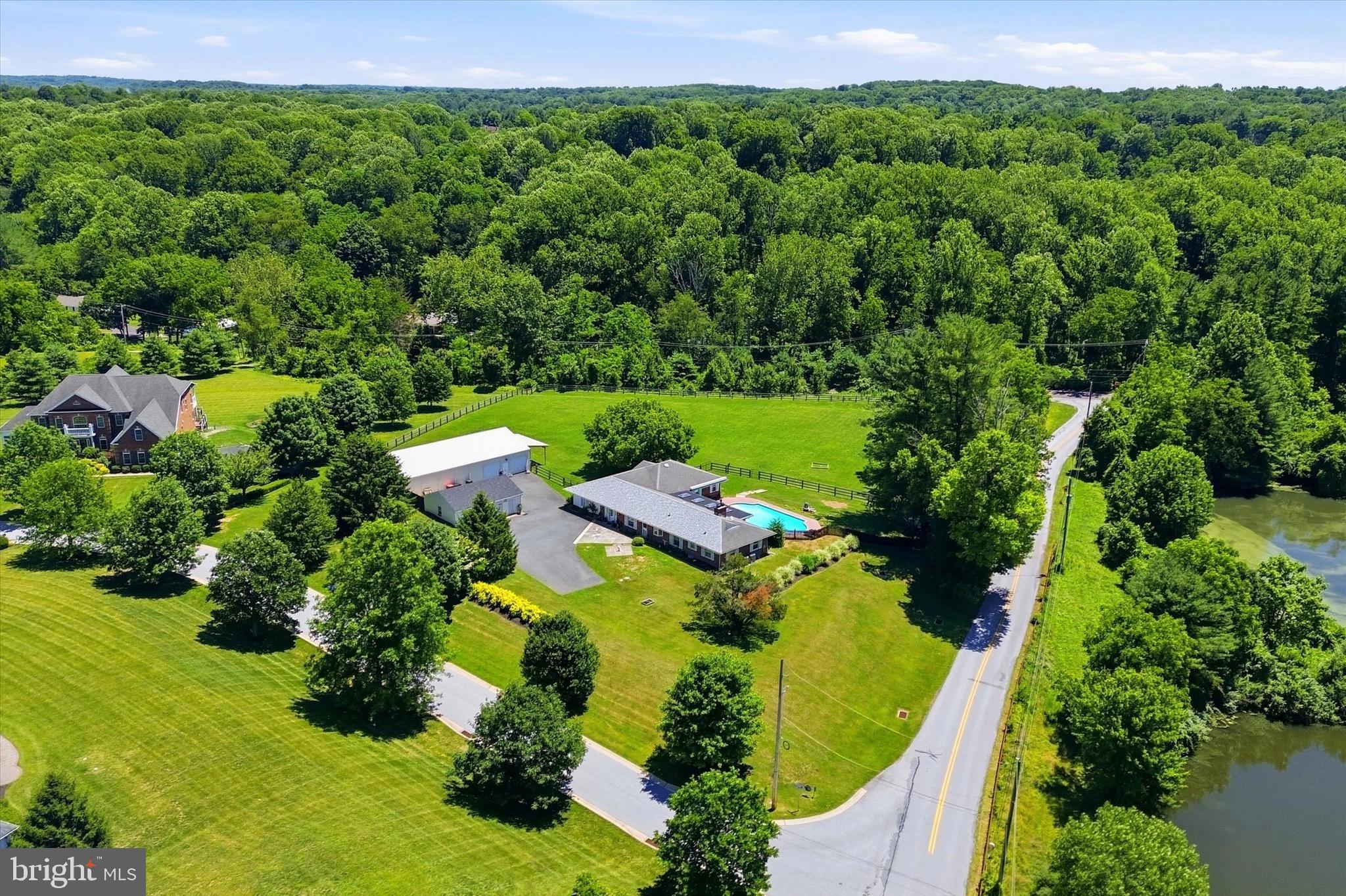 Nestled in desirable Pocopson Township within West Chester and located in the highly sought-after Unionville-Chadds Ford School District, this unique ranch-style home offers the perfect blend of charm, privacy, and modern comfort on 3.88 picturesque acres. Originally part of a historic 100-acre Pocopson Township farmhouse property, this residence provides a peaceful country setting while remaining just minutes from the shops, dining, and amenities of downtown West Chester.

Step inside to discover a spacious and inviting layout, where slate flooring accents the foyer, and the living room sits just to the left, featuring custom built-ins that add both character and functional storage. The home offers five generously sized bedrooms and three and a half bathrooms, providing plenty of room for comfortable living.

The eat-in kitchen serves as the heart of the home, complete with a cozy fireplace, a large island with seating, and ample space for casual dining. Just off the kitchen is a separate formal dining room, ideal for hosting gatherings and special occasions.

Glass sliding doors from the kitchen lead into a bright and spacious sunroom, filling the home with natural light. From the sunroom, step outside to the patio and fenced-in pool area, creating a seamless indoor-outdoor flow that’s perfect for summer entertaining or quiet evenings enjoying the surrounding property.

The primary bedroom includes its own private en-suite bathroom. Two additional bedrooms are located in the same wing of the home and share a convenient Jack-and-Jill bathroom. On the opposite side of the home are the fourth and fifth bedrooms, one currently used as a home office, along with a full bathroom—creating an ideal setup for guests or a potential in-law suite with added privacy.

This home also offers abundant storage throughout, along with a basement that provides additional storage space. The classic brick construction ensures durability while maintaining timeless curb appeal.

Outside, the expansive grounds offer exceptional versatility. The property includes an oversized detached two-car garage and a 40’ x 60’ pole barn/workshop with an attached 32’ lean-to—perfect for horses, equipment, or additional storage. With horses permitted, the acreage offers flexibility for a variety of rural lifestyle needs.

Offering peaceful country living with convenient access to West Chester’s vibrant downtown, this one-of-a-kind property is a rare opportunity to enjoy space, character, and flexibility in a beautiful and private setting.