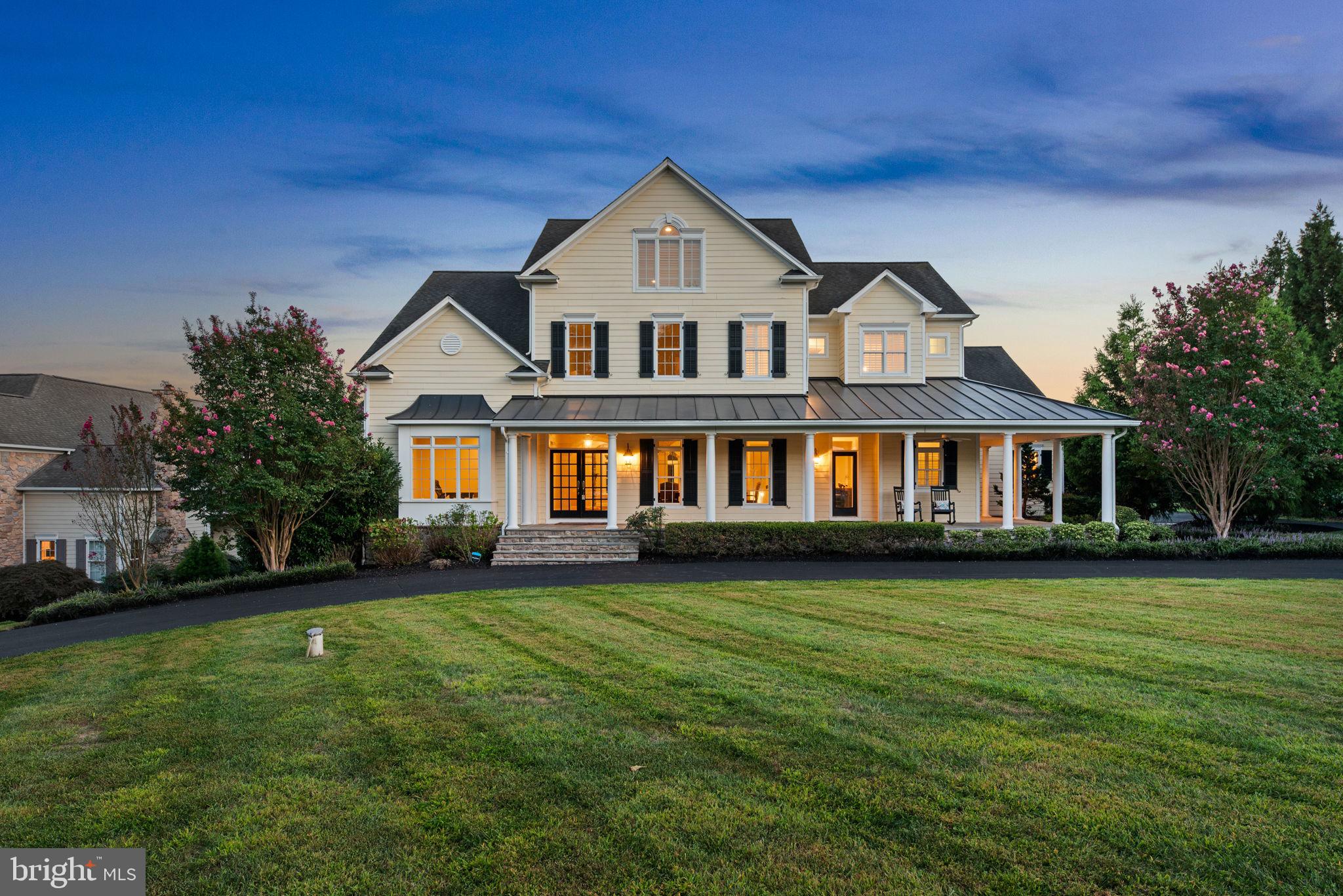 An expansive circular driveway framed by lush landscaping leads to a 2 1/2-car side garage and this stately colonial residence, featuring charming pale yellow Hardiplank siding and stone with classic black shutters and elegant double French front doors. The home is graced by a wrap-around stone front porch with multiple access points, ideal for relaxing mornings while enjoying the serene views.

The interior is meticulously designed with pristine attention to detail, showcasing grand arched doorways, elegant columns, recessed lighting, and intricate crown moldings. Hardwood floors flow through expansive open living spaces, all enhanced by custom finishes and luxurious touches, creating an atmosphere of timeless sophistication throughout the home. 

Proceed into the open-concept kitchen and adjoining keeping room, highlighted by a cozy gas fireplace. The sun-drenched family room boasts another gas fireplace, framed by floor-to-ceiling stone, with a stylish alcove for a large television and access to the serene back porch. The main level also includes a versatile bonus room with custom built-ins, ideal for an office or study area, a convenient mudroom, a meticulously designed laundry closet, and two elegantly appointed powder rooms. 

The updated eat-in kitchen features top-of-the-line GE Monogram® stainless steel appliances and gleaming hardwood floors. An expansive island with seating for at least three serves as a focal point, complemented by a white subway tile backsplash, elegant granite countertops, ample 42” cabinets, including some with glass fronts for added charm, an integrated refrigerator, dual pantries, and a stunning custom stone range hood cover.

The owner’s suite, conveniently located on the main level, offers a luxurious retreat with its own gas fireplace and plush carpeting. Enjoy private access to the screened porch, perfect for relaxing in solitude. The suite features an expansive walk-in closet with custom built-ins and an adjoining spa-like bathroom. This exquisite bathroom includes an air-jetted tub, a walk-in Roman® shower with a sleek, doorless design, a separate water closet, and dual vanities for added convenience.

Upstairs is a versatile loft space with built-in bookcases, a second laundry room, and three generously sized carpeted bedrooms each with a walk-in closet and attached full bathroom. Two of these bedrooms are connected by a whimsical secret pass-through. The uppermost level houses an oversized fourth bedroom with an attached full bathroom for extra privacy.

The lower level is an entertainer’s dream, featuring a sprawling recreation room that seamlessly opens to a covered patio with a unique patterned ceiling. Enjoy movie nights in the thrilling tiered home theater or transform the bonus room into your personal home gym. This level also includes a convenient third laundry room, a spacious sixth bedroom, and two full bathrooms, making it ideal for hosting unforgettable gatherings or creating your own entertainment hub.

This breathtaking backyard oasis is the ultimate luxury escape, crafted to leave a lasting impression. Dive into the saltwater pool with a stunning waterfall feature, diving board, and a thrilling, oversized slide, all framed by lush, manicured landscaping. Unwind in the hot tub or gather around the built-in fire pit for cozy evenings. The expansive tiered patio and enclosed screened composite porch provide perfect settings for alfresco dining and seamless indoor-outdoor entertaining. With an open yard backing to serene woods, this fully fenced retreat offers both privacy and picturesque views, creating a truly unparalleled outdoor haven.

Fox Meadow is a picturesque community with rolling countryside and beautifully landscaped lots. Residents enjoy rural tranquility while being close to popular destinations like Turf Valley Towne Square, Patapsco State Park, cozy local eateries, upscale restaurants, and commuter routes I-70, Route 32, and Route 29.