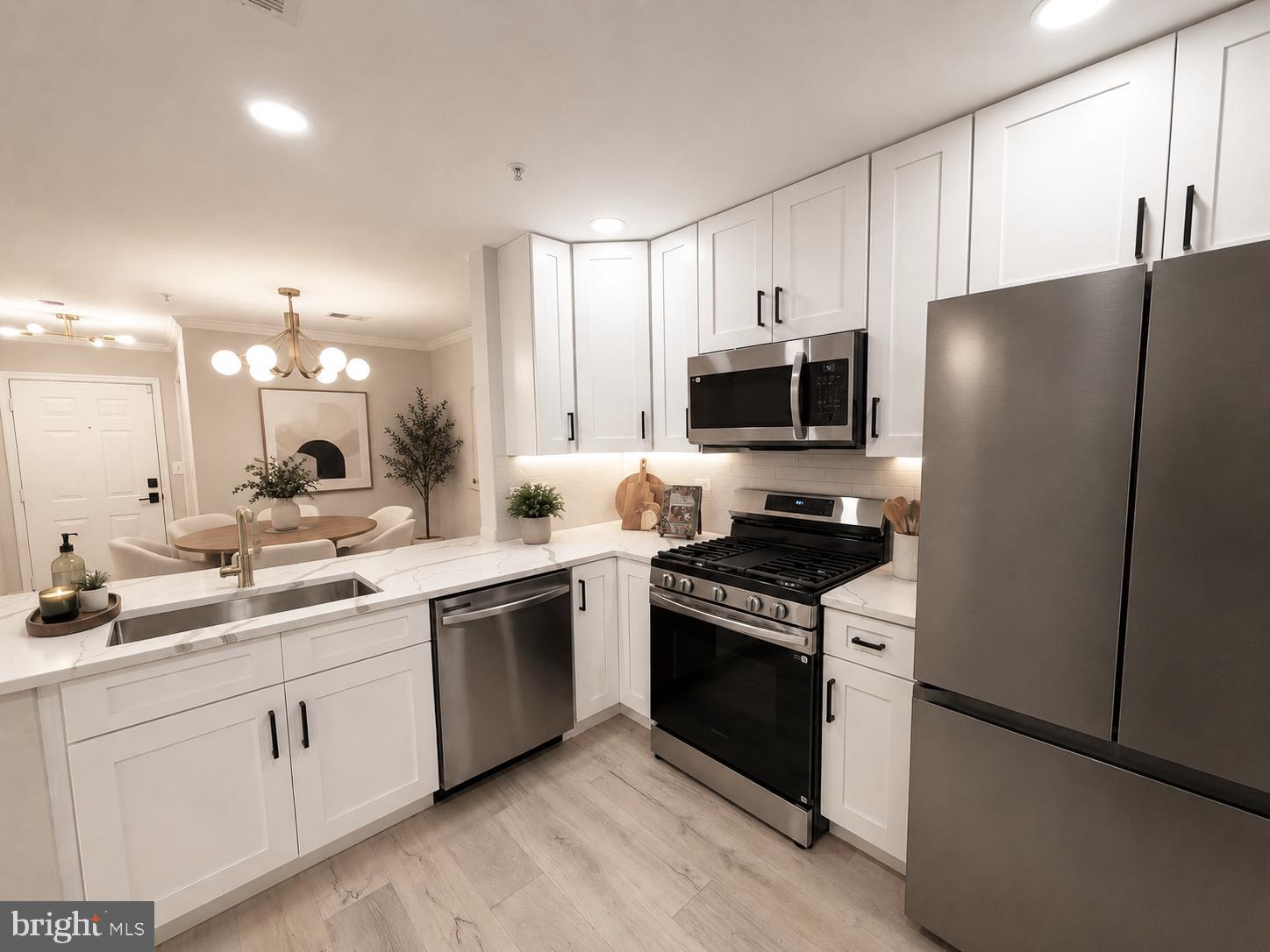 Rare ground-floor, no-step entry condominium with a private patio in the highly sought-after King Farm community. This stunning designer-updated home offers refined living with a sophisticated modern aesthetic and exceptional attention to detail.

The showpiece renovated kitchen features custom white shaker cabinetry, Calacatta quartz countertops, and premium stainless steel appliances—perfect for everyday living and entertaining. Wide-plank hardwood flooring, updated lighting, and fresh designer paint create a bright, upscale interior throughout.

The spacious layout flows seamlessly to the private patio, offering a rare ground-floor outdoor retreat ideal for relaxing, entertaining, or enjoying morning coffee.

Currently assigned to Julius West Middle School and Richard Montgomery High School, this home is ideally situated to enjoy all that King Farm has to offer. Residents have access to exceptional community amenities, including a clubhouse, swimming pools, parks, playgrounds, tennis courts, basketball courts, and scenic walking trails.

Ideally located within walking distance of the Metro , and easy access to shopping, dining,  and commuter routes. A rare opportunity to enjoy stylish, low-maintenance living in one of Rockville’s most desirable communities—schedule your private showing today!