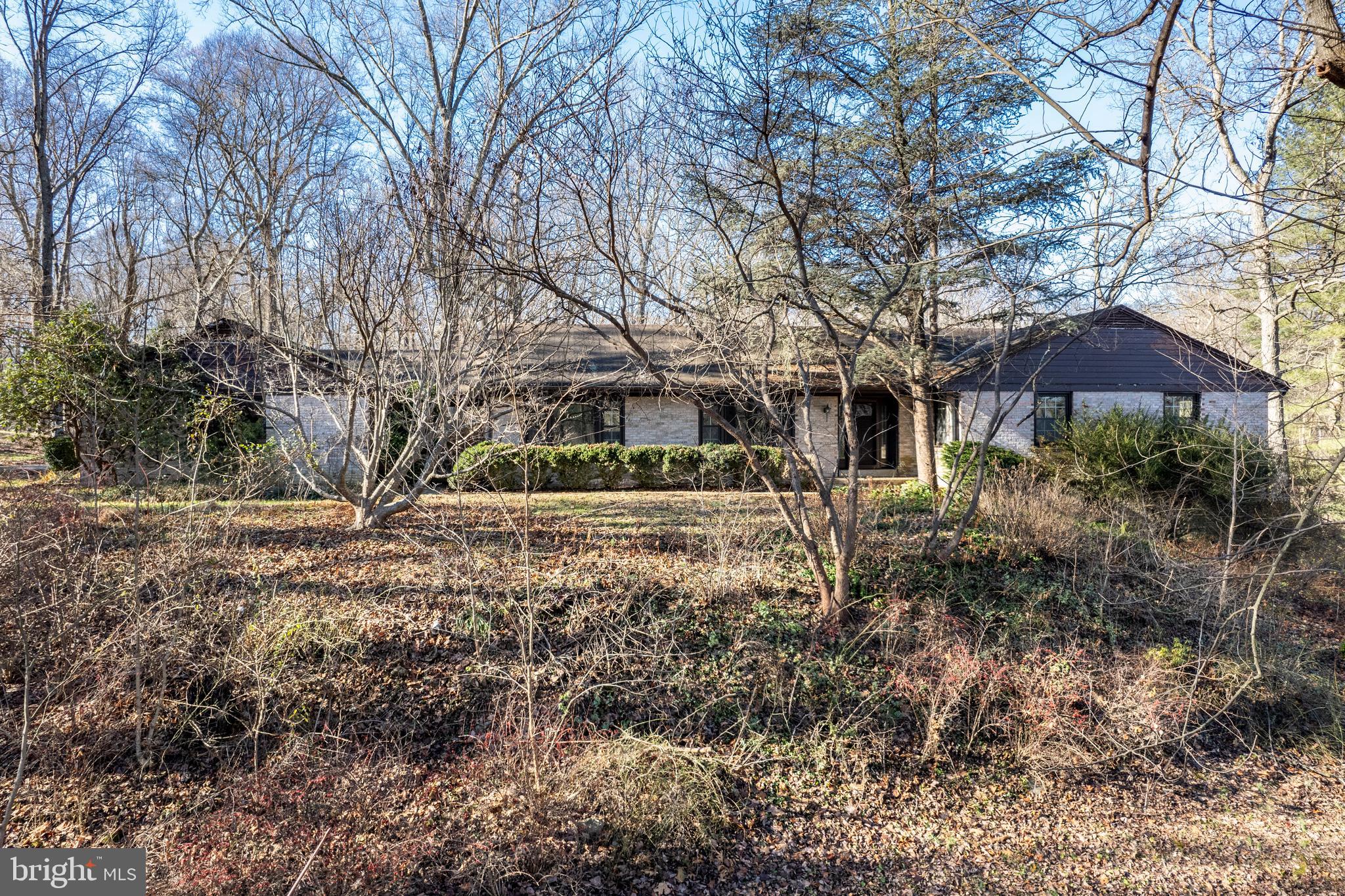 This one-of-a-kind, custom-built, all-brick rancher is a true gem, nestled atop a scenic hill on over 7 wooded acres, backing to Patuxent River State Park.  This  one owner home offers an unmatched combination of space, functionality, and charm.

Step inside to discover an updated kitchen featuring granite countertops and stainless steel appliances, seamlessly flowing into the cozy family room with a wood-burning fireplace—perfect for gatherings or quiet evenings. The home also boasts a large living room and formal dining room, ideal for entertaining or special occasions.

The spacious primary suite offers privacy with an en-suite bath, while three additional large bedrooms on the main level provide plenty of flexibility. The finished basement adds even more living space with a fifth bedroom, a full bath, a generous recreation room, and a utility room.

The breezeway leads to an oversized two-car garage, offering convenience and additional storage. There is an additional two car garage.  Outside, the sprawling property provides endless possibilities—whether you’re enjoying the wooded views, creating outdoor retreats, or exploring the surrounding Park.

This home is a rare find, offering privacy and nature while still being close to Washington DC.