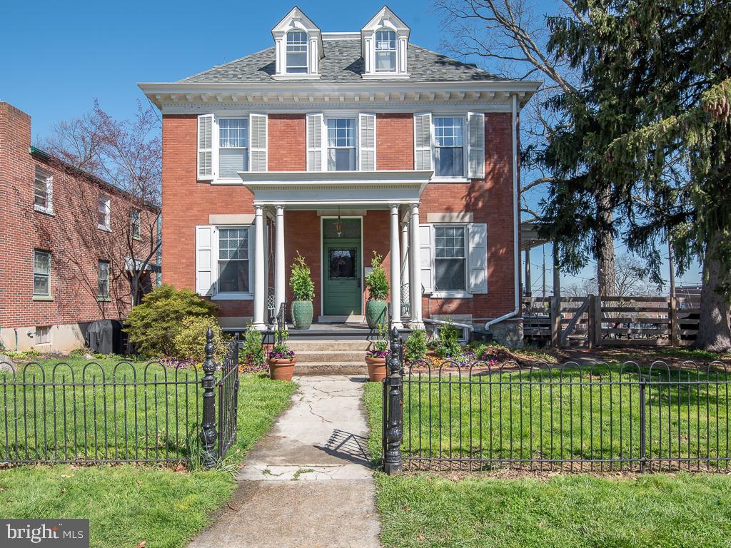Bold, Artistic, & Warm. 1047 East Orange St is in a class of its own. This home has been beautifully and artfully designed with a mix of materials throughout that pay homage to its historic, architectural style. Upon entering you will be greeted by a combination of original wood details, loads of natural light, and an updated aesthetic that together creates a feeling of warmth and magic. The first floor boasts many large rooms, a powder room, original solid wood pocket doors, & original heart pine floors. The kitchen has been professionally designed with a large pantry, stone countertops, and intriguing tobacco lath walls.  The second and third floors include 6 large bedrooms and a beautifully restored, full bath. The massive yard is enclosed by a 6 foot horse fence as well as the original 2-story carriage house that includes a rustic entertaining space on the second floor. This solid home has integrated rain spouting, replacement windows, a walk out basement as well as a newer roof and mechanicals. Basically, it’s a dream living space closer to city living but with the features of a historic farmette. Come and see the beauty and magic for yourself.