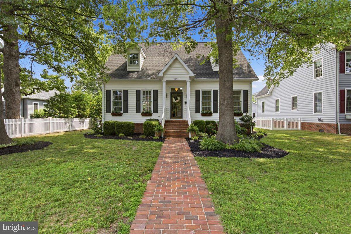 Meticulously maintained and surrounded by mature landscaping, this 3BR/2.5BA expanded Cape Cod-style home is in the desirable Hambrooks neighborhood. Follow the brick walkway to the covered front porch and step inside a home filled with natural light, gorgeous Brazilian Cherry hardwood flooring, recessed lighting, a soft neutral color palette, and a thoughtfully designed floor plan. The inviting living room, highlighted by a cozy gas fireplace, flows seamlessly into the large dining room and well-appointed kitchen, creating the perfect setting for everyday living and entertaining. The kitchen boasts abundant cabinetry, including a pantry cabinet, stainless steel appliances with a slide-in gas range, a double porcelain sink set into a peninsula, and generous counter space for meal preparation. Just beyond the kitchen are the convenient main-level laundry room and access to the backyard. The main level also offers a comfortable family room, a half bath, and an impressive primary suite complete with a large walk-in closet and private en-suite bath with a deep jetted soaking tub, double vanity, and walk-in shower. Upstairs, you'll find two generously sized bedrooms, a full hall bath, a versatile bonus room perfect for a home office, playroom, hobby room, or guest space, along with hidden storage. Step outside from either the dining room or laundry room onto the expansive wood deck overlooking a beautifully landscaped backyard complete with mature plantings, hardscaping, a patio, and winding pathways leading to the detached two-car garage. Equipped with electric service and a mini-split providing both heating and air conditioning, the garage is well suited for a workshop, hobby space, home gym, or additional flex space. Located just moments from the waterfront, this exceptional home offers partial water views from the rear deck and second floor while remaining close to shopping, restaurants, parks, and commuter routes.