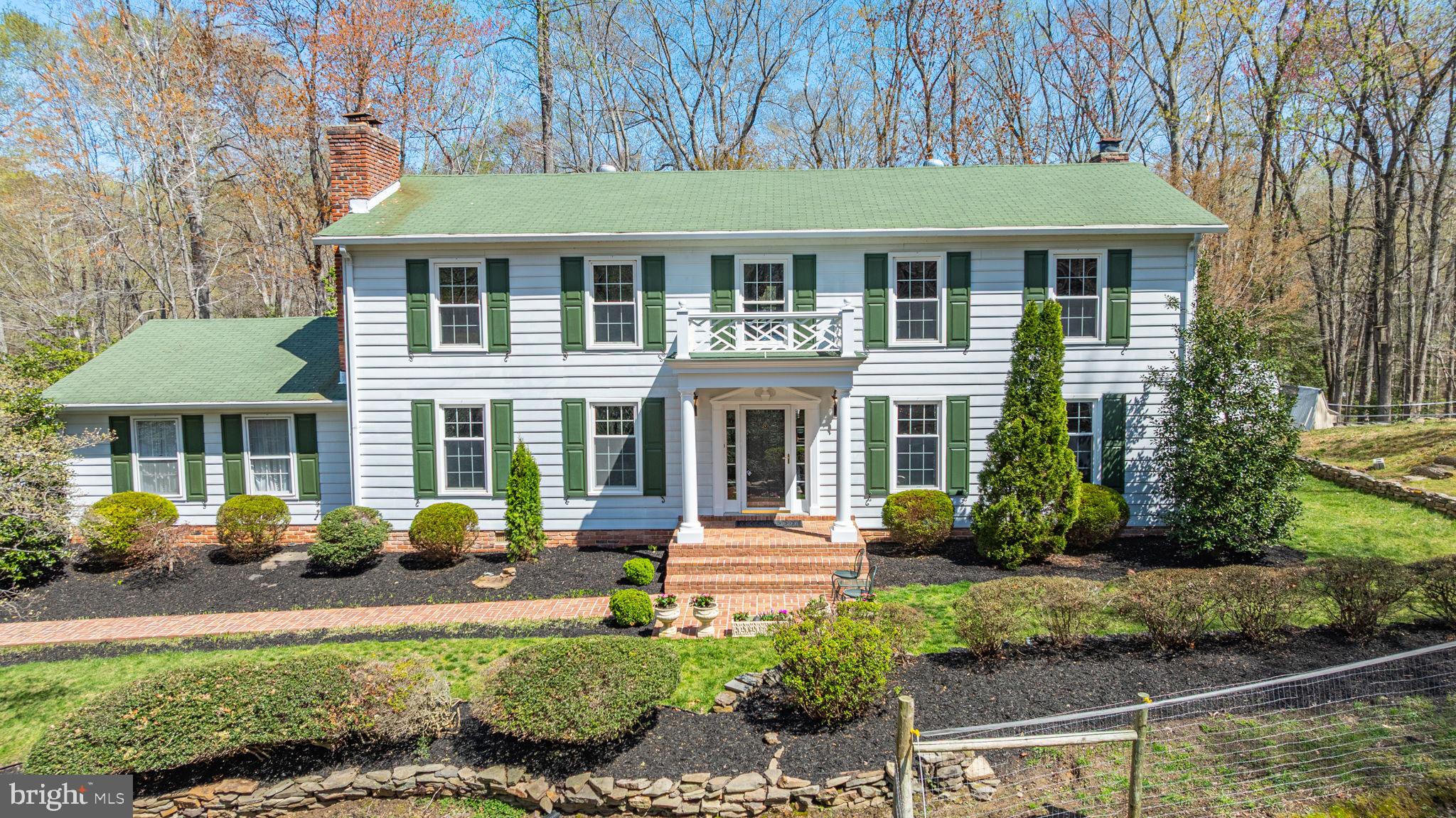 Tucked away on 3.57 beautiful acres, this meticulously maintained home offers a rare blend of space, style, and seclusion—close to the water. From the moment you arrive, pride of ownership is unmistakable, beginning with the welcoming brick walkway and charming covered front porch.  Inside, you'll find four spacious bedrooms!  Need more space? The expansive upstairs second family room provides easy potential to add one or two additional bedrooms.  Warmth and character shine throughout the home with rich hardwood floors and three fireplaces that grace the dining room, main-level family room, and luxurious primary suite.  Thoughtful upgrades include 2020 Thompson Creek windows on the main level, enhancing comfort and providing energy efficiency.  Outside, enjoy the tranquility of your own private retreat. Mature trees and professional landscaping surround the home  while the tin-roofed carriage house offers covered parking and a loft with lighting ideal for extra storage, a workshop, or creative studio.  Want horses?  The yard is fenced and ready!  Located in the sought-after Ferry Landing Woods community with no HOA residents can opt into the Voluntary Civic Association ($125/year), which includes access to the private boat ramp, waterfront pavilion, and vibrant community events.  It's an easy commute to DC, JB Andrews, and Coast Guard Headquarters.  Come see for yourself why life in Ferry Landing Woods is truly something special.