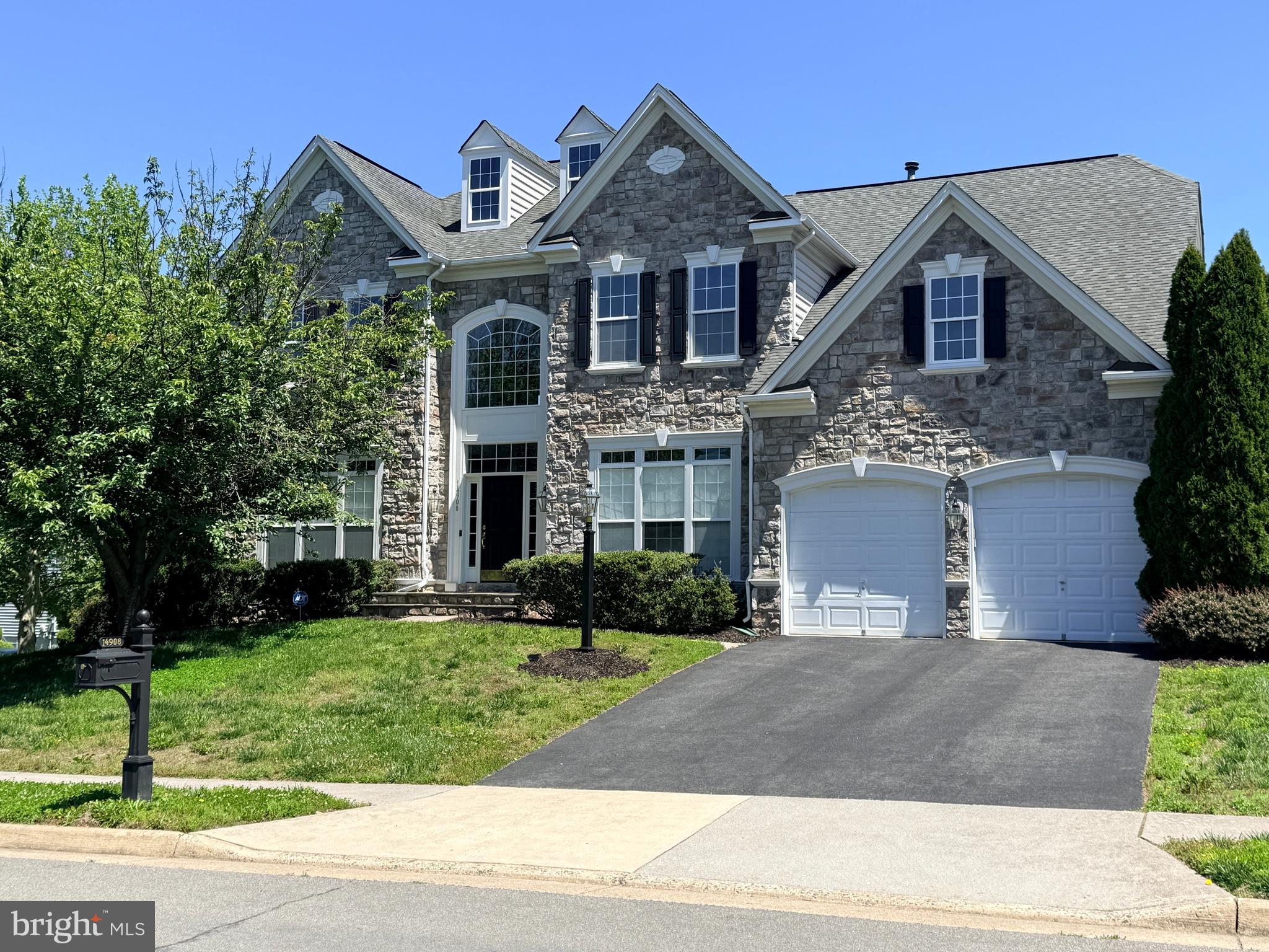 Welcome to this beautifully maintained rough-hewn stone-front colonial in the sought-after Gates Mill community of Haymarket. Offering over 5,100 square feet of finished living space, this spacious home features 4 bedrooms, 4 full baths, and 1 half bath designed for comfortable everyday living and effortless entertaining. It is a 15-minute walk or 5-minute bike rider to Battlefield High School.

The main level boasts formal living and dining rooms, a private home office/music room, and an expansive family room with abundant natural light and gas-lit stone fireplace. Tall floor-to-ceiling windows with transoms grace the main level. The well-appointed kitchen opens to the family room and breakfast area, creating a functional and inviting gathering space. A light-filled sunroom with a palladium window also opens into the kitchen. Upstairs, the generous primary suite includes a sitting area, two large walk-in closets, and a luxurious en-suite bath with dual vanities and soaking tub. Three additional upstairs bedrooms and two ensuite bath accommodations provide ample space for family and guests.

The finished lower level offers flexible living space ideal for recreation, fitness, media, or guest accommodations, complemented by a full bath. The unfinished basement area provides abundant indoor storage. Situated on a quiet residential street, the home is conveniently located near shopping, dining, commuter routes, community ball fields, wineries, golf courses, and the many amenities that make Haymarket one of Northern Virginia's most desirable communities.

Combining exceptional space, a highly functional floor plan, and an outstanding location, this Gates Mill residence presents a rare opportunity to enjoy refined living in the heart of Prince William County.