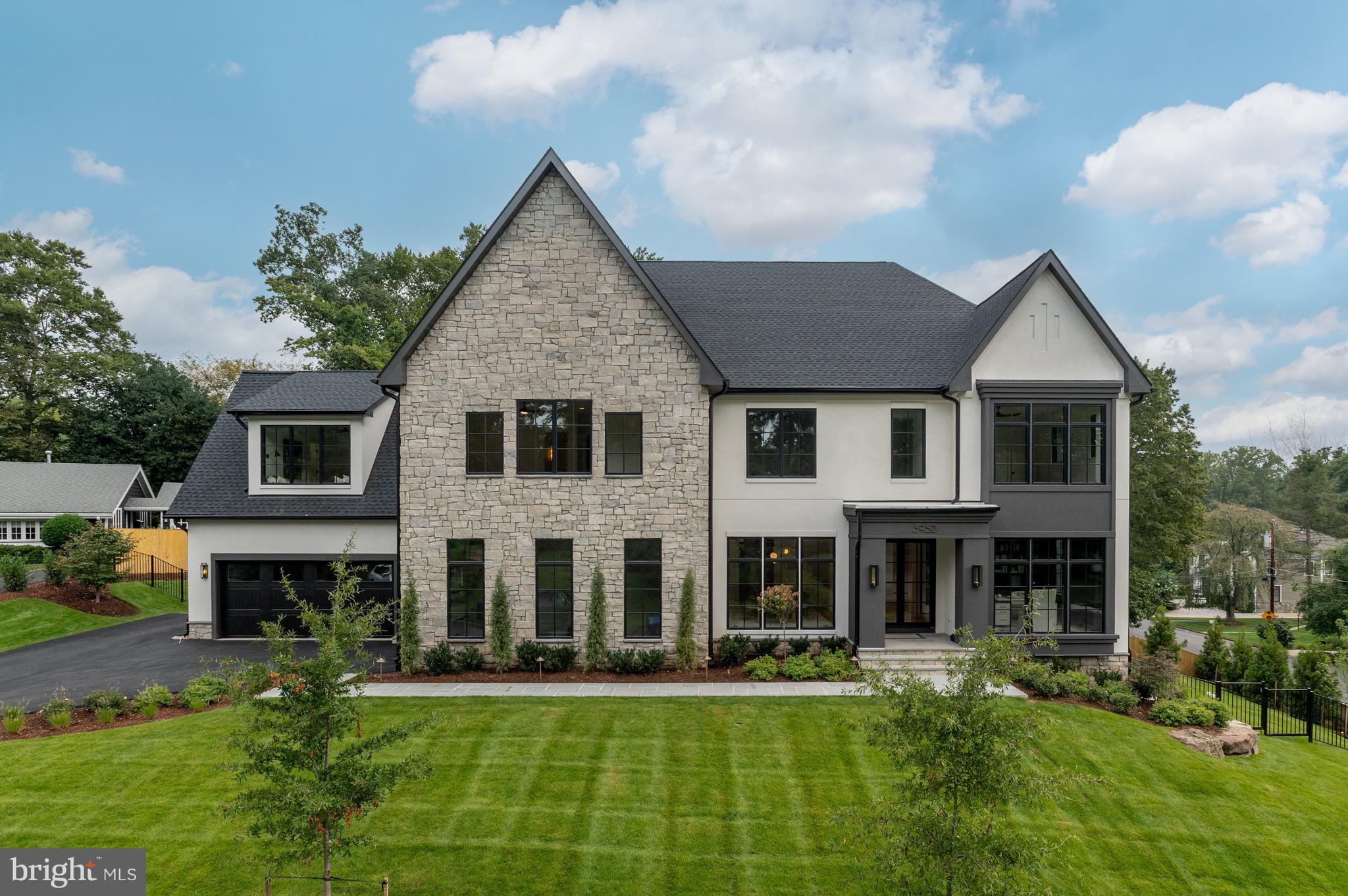 Elevation Homes, in collaboration with DC-based Ariella Designs, introduces an exceptional custom residence that redefines modern luxury in Chesterbrook Woods, one of McLean’s most coveted neighborhoods.  Sited on an elevated 0.42-acre lot, this 6 Bedroom, 7 Full Bath, and 3 Half Bath home spans over 9,000 square feet, offering interiors that balance timeless sophistication with contemporary comfort.  

Across three expansive levels, this home showcases transitional architecture with organic elements, including wide plank white oak flooring, Visual Comfort lighting, marble and quartzite surfaces, and black-framed windows for a clean, elevated look. The main level has 10' ceilings and includes a sun-filled great room with a dramatic fireplace, a private guest suite, and a designer kitchen with an oversized waterfall island and Wolf/Sub-Zero appliance suite.  Sliding glass doors open to a screened porch featuring a second fireplace, vaulted ceiling, and heaters—perfect for indoor-outdoor living.

Upstairs, the primary suite features a fireplace, a built-in coffee bar, sitting room, two walk-in closets with custom closet systems, and a luxurious ensuite bath with honed marble finishes, dual vanities, a soaking tub, and frameless glass shower. Three additional bedrooms, each with ensuite bathrooms featuring designer vanities and upgraded finishes. A bonus room suite offers a custom-built window seat and additional flexible space.

With 10' ceilings, the lower level is designed for entertaining and wellness, offering a spacious rec room with a wood-accented ceiling and fireplace, custom game area, a full wet bar with large island, brass mesh front cabinetry, and a 650-bottle temperature-controlled wine room, as well as a fitness room with full length mirror wall.  A separate guest room and full bath complete the level.

Additional features include elevator-ready infrastructure, four fireplaces, a three-car garage, integrated dog wash station in the mudroom, back staircase to upper level suite, and custom millwork throughout. Located minutes from parks, trails, Chesterbrook Shopping Center, downtown McLean, and major commuter routes, this home delivers extraordinary comfort, thoughtful detailing, and modern livability in one of McLean’s most desirable communities.